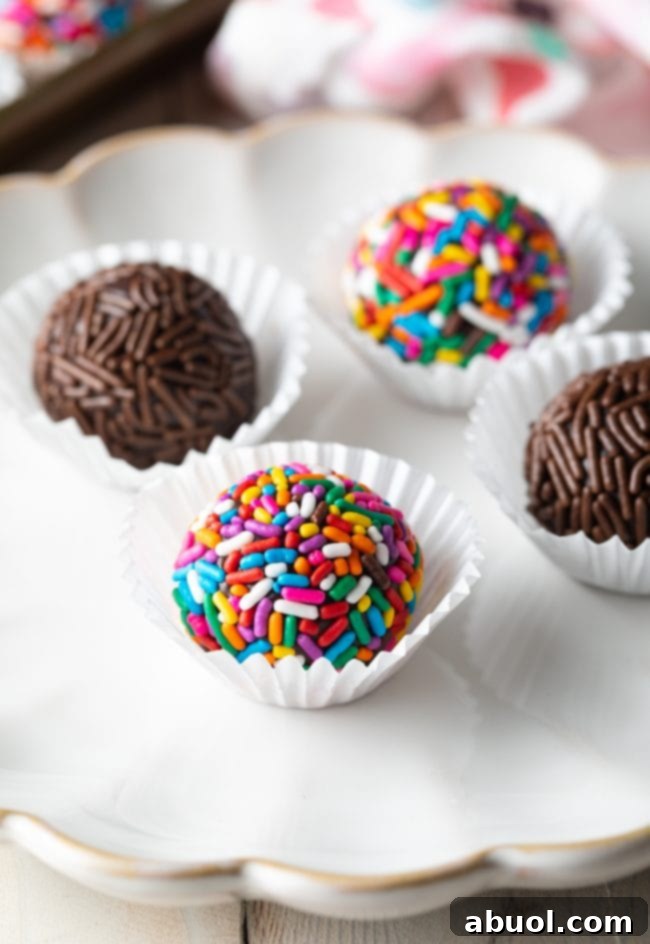 Closeup of 4 brigadeiros on a serving plate. 