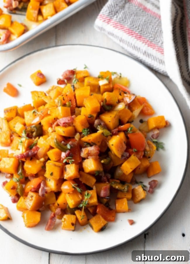 Top-down view of Sweet Potato Hash Browns (Potatoes O'Brien) on a white plate, garnished with fresh herbs.