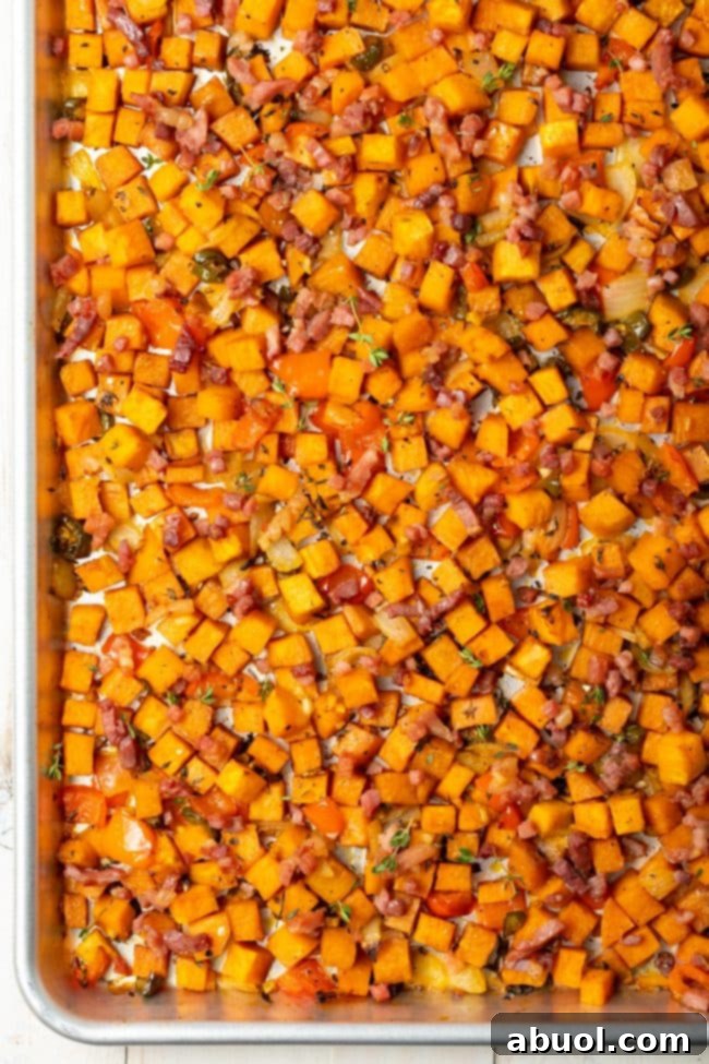 Overhead view of a baking sheet filled with perfectly roasted sweet potato hash browns, golden and inviting.