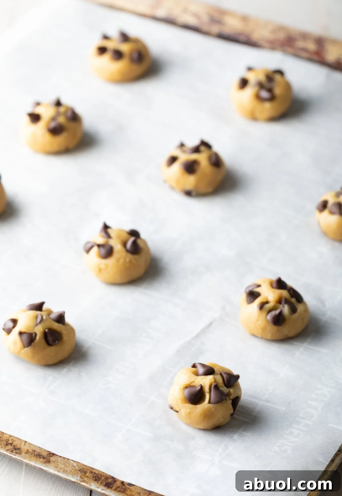 Salted Chocolate Chunk Delights 9 A dozen raw chocolate chip cookie dough balls arranged on a baking sheet, ready to be baked.