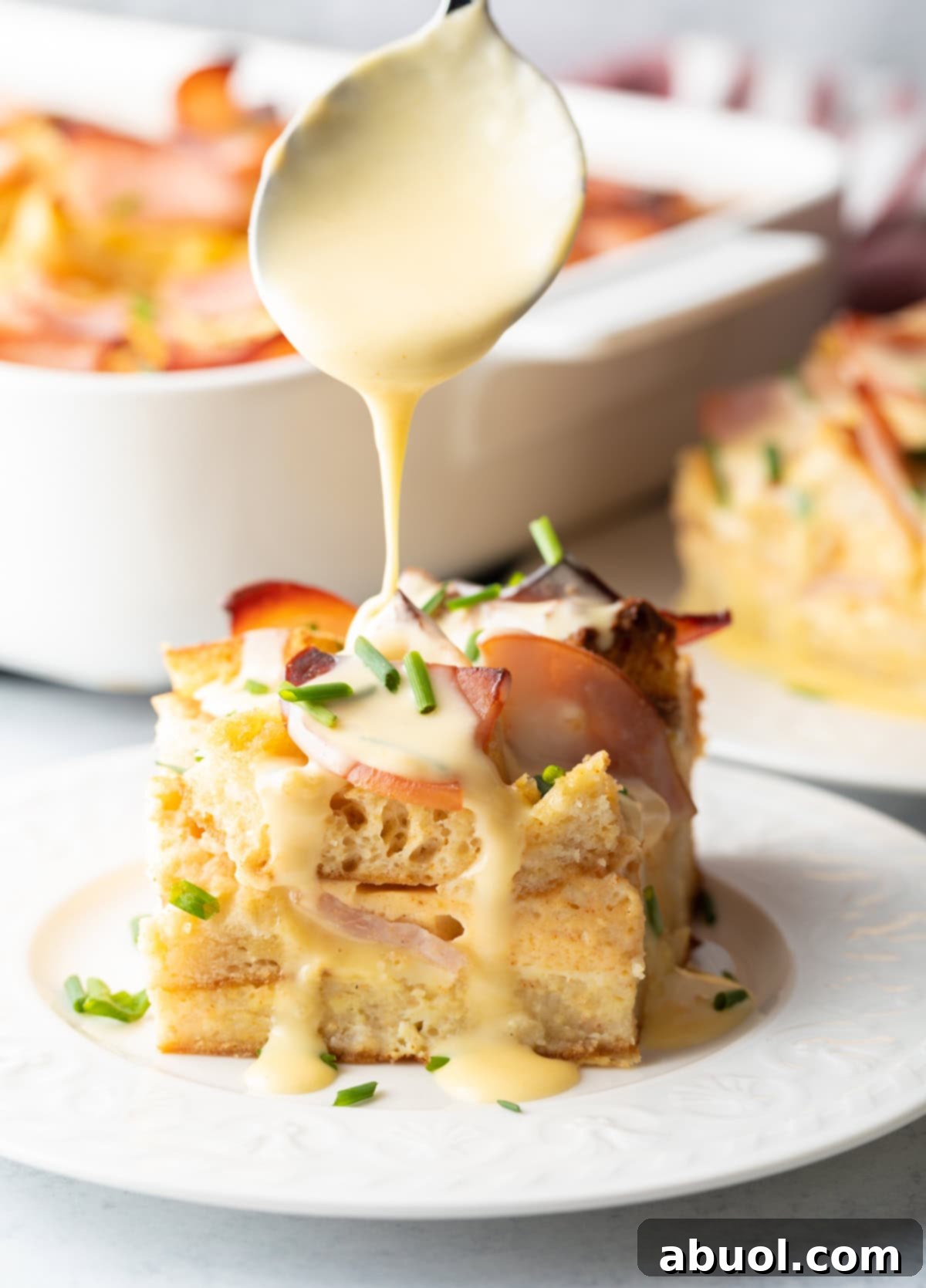 Slice of Eggs Benedict Casserole with Hollandaise sauce drizzle