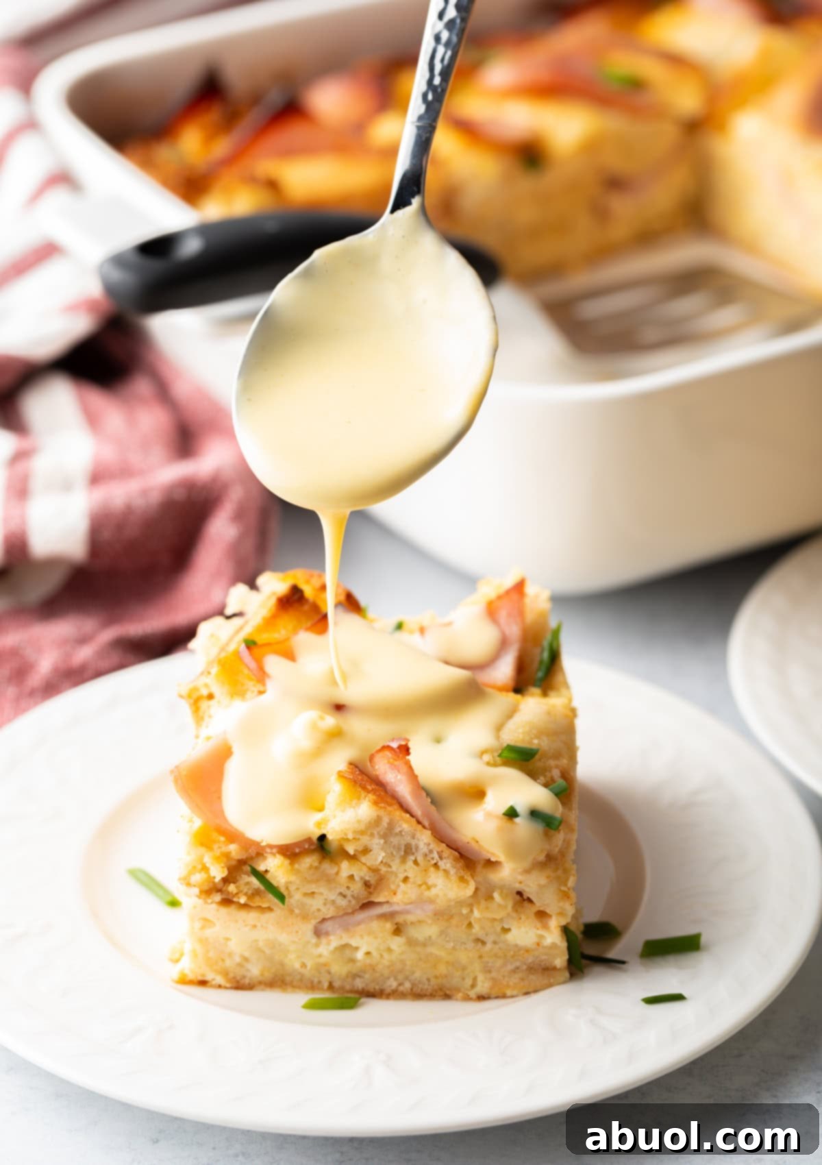 Eggs benedict casserole slice being prepared
