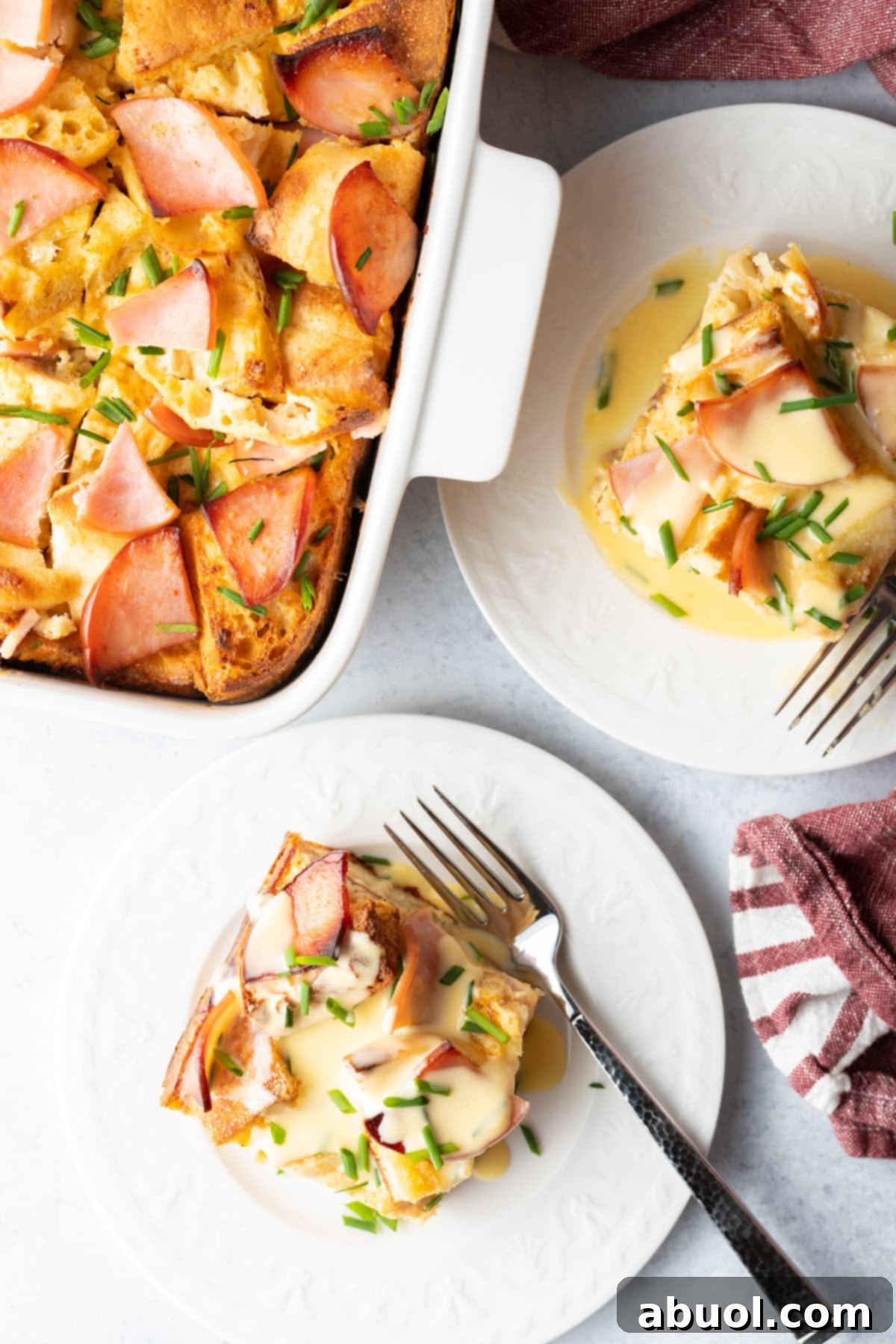 Overhead shot of slices of Eggs Benedict Casserole on white plates
