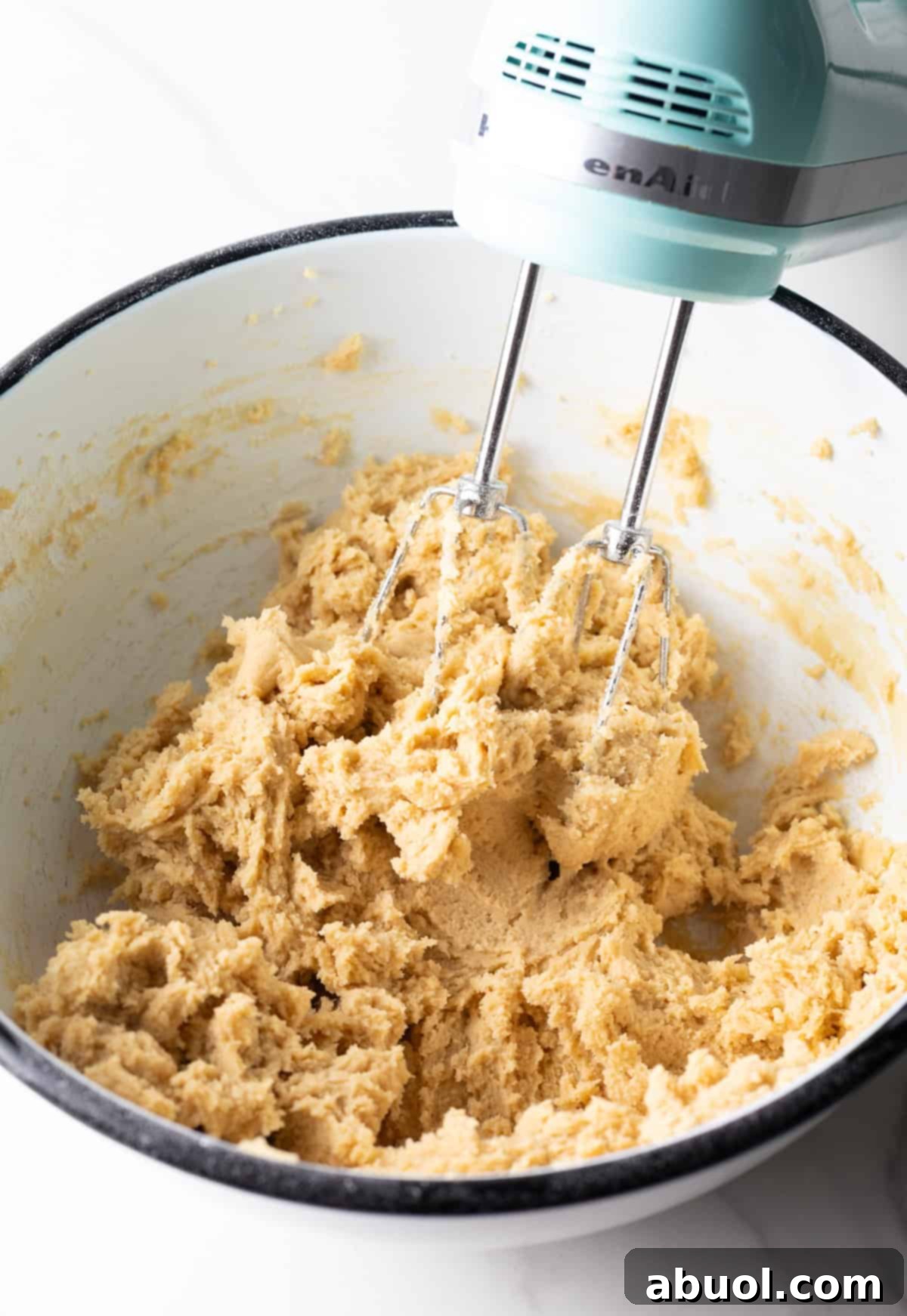 Mixing the cookie dough with an electric mixer.