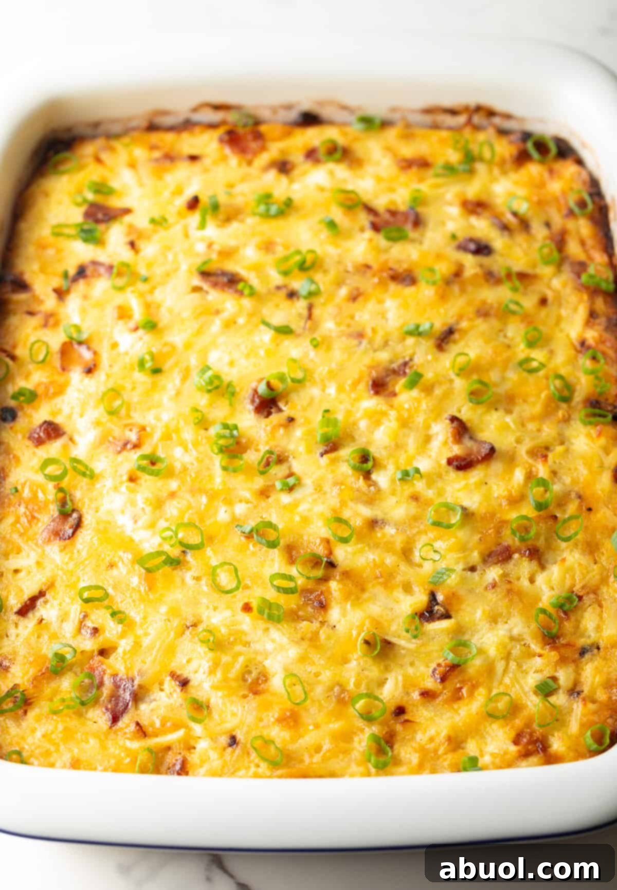 Amish Breakfast Casserole: White rectangle baking dish with baked Amish breakfast casserole.