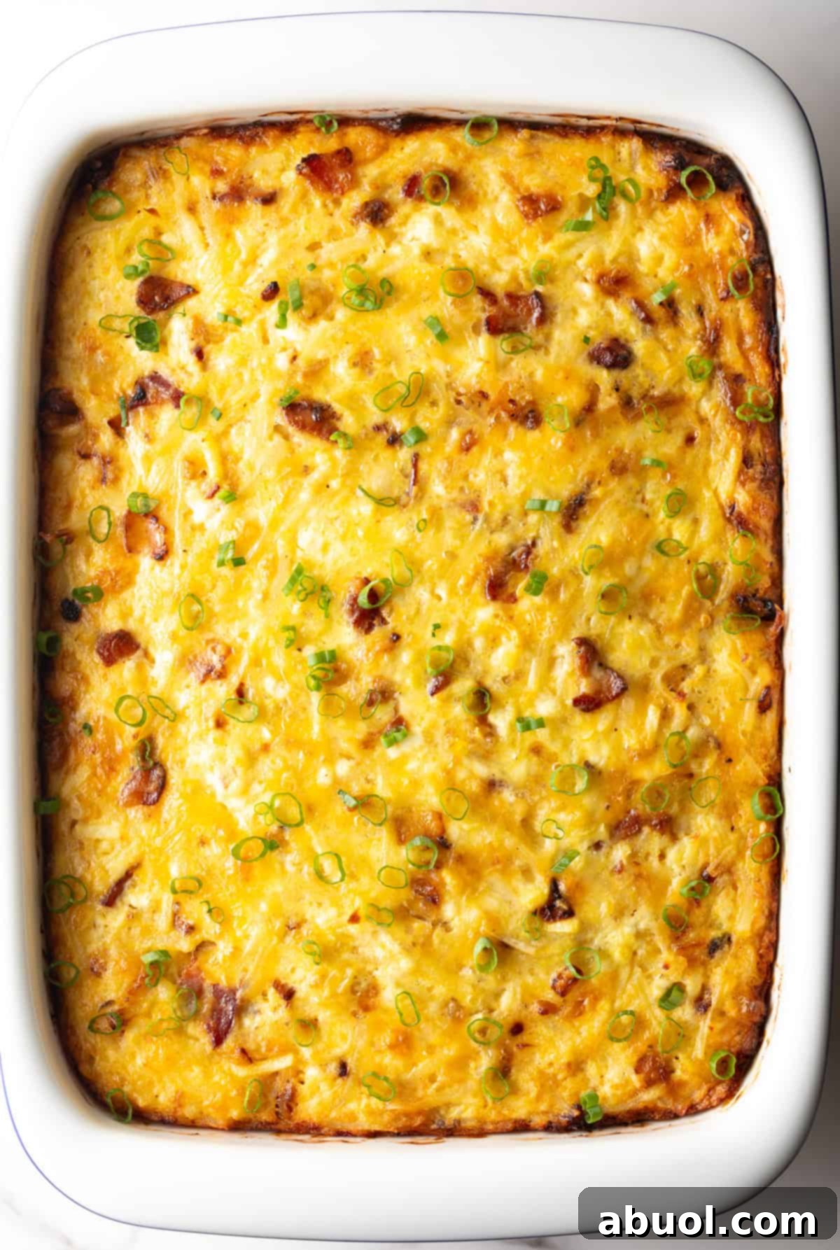 Amish Breakfast Casserole: Top down view white rectangle baking dish with baked Amish breakfast casserole.