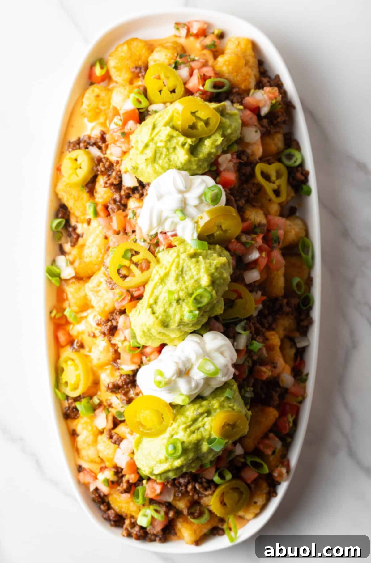 Overhead view of loaded tater tot nachos with classic toppings