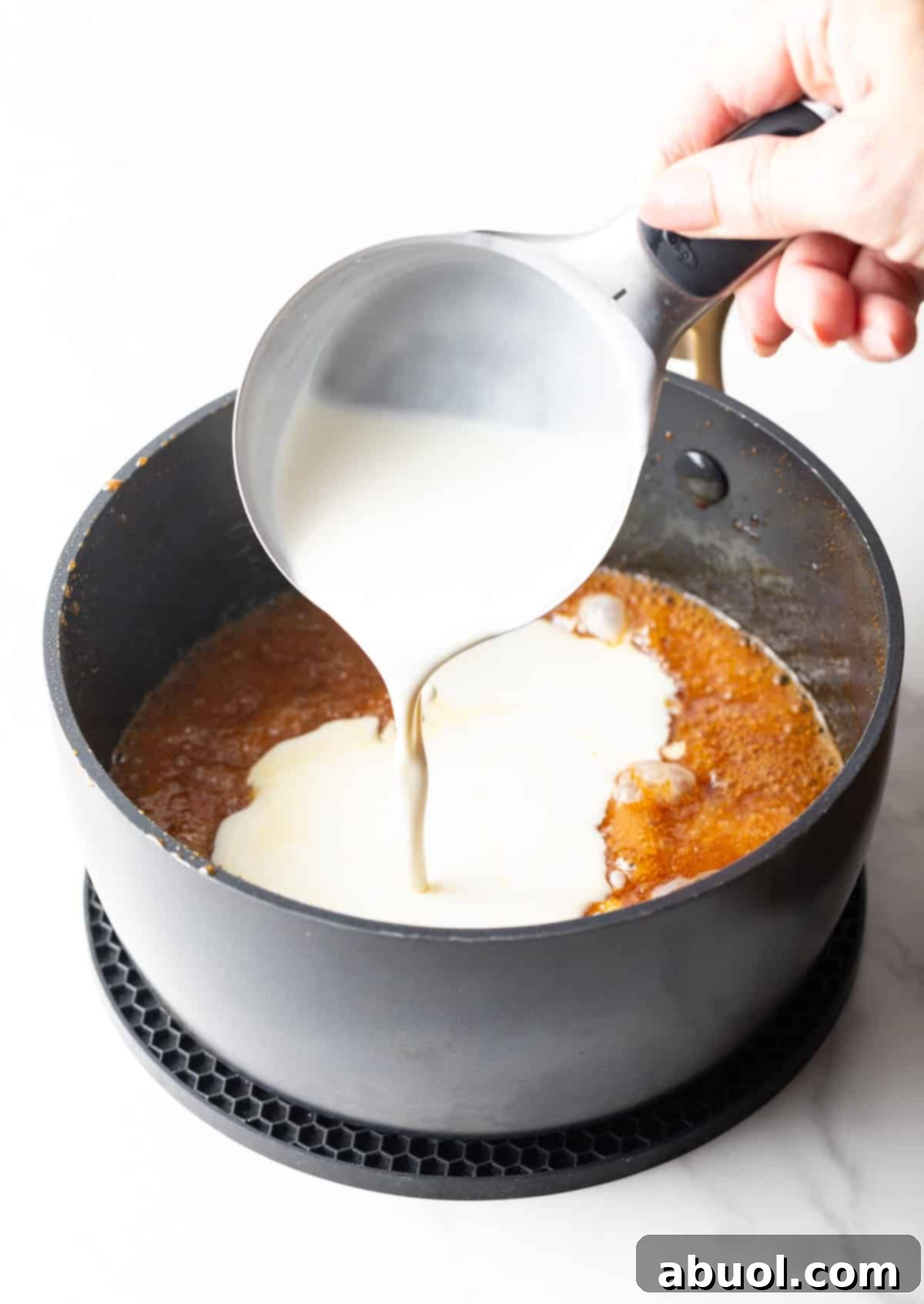 Cream being added to salted caramel sauce mixture