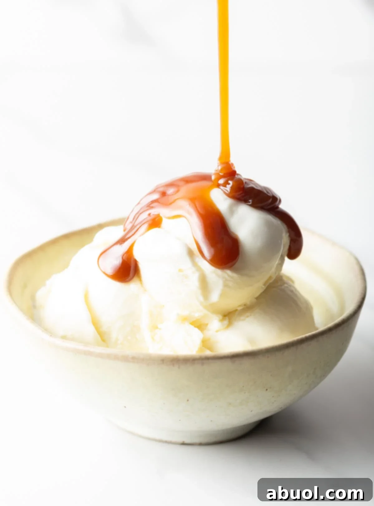 Salted caramel being drizzled over vanilla ice cream