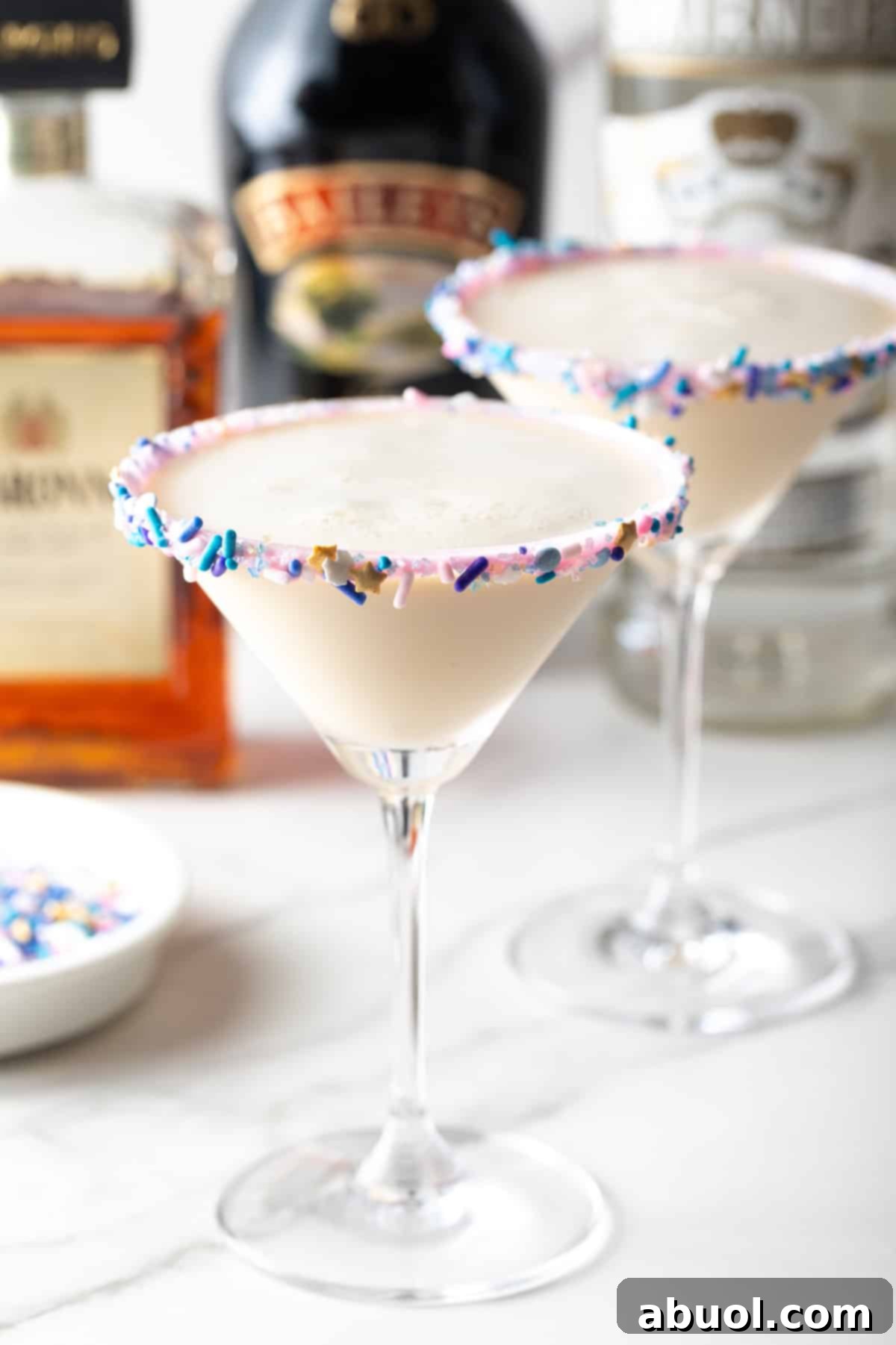 Sugar cookie martini cocktail with rainbow sprinkles on rim, festive brunch drink, dessert-inspired beverage, sweet party cocktail, highlighting its vibrant colors and dessert-like qualities.