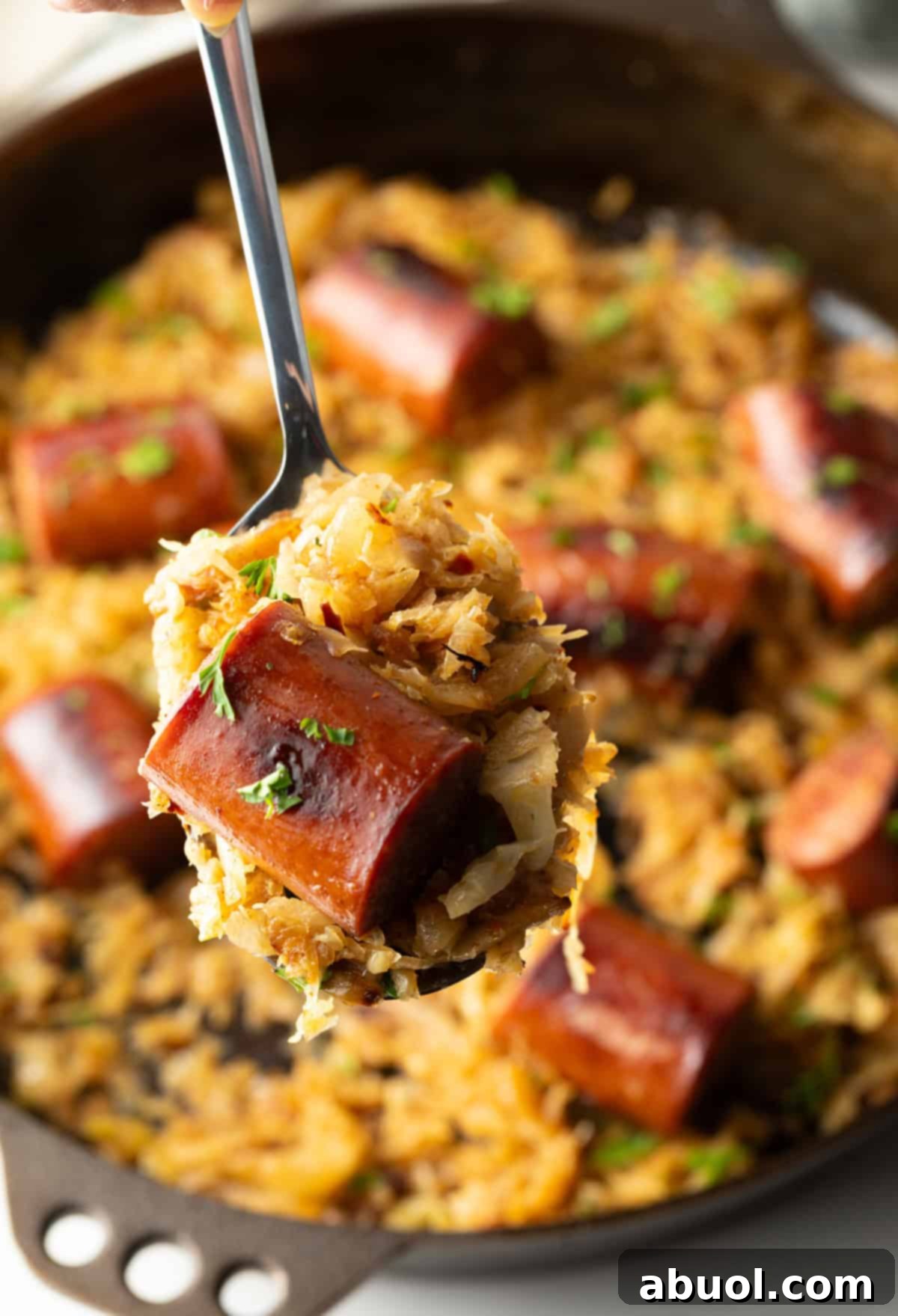 Close up of cooked sausage and sauerkraut on a spoon