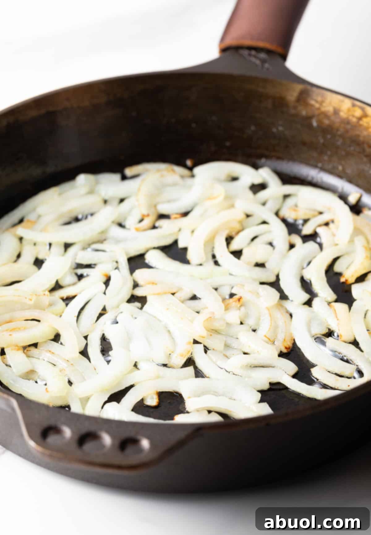 Onion slices sautéing in a skillet