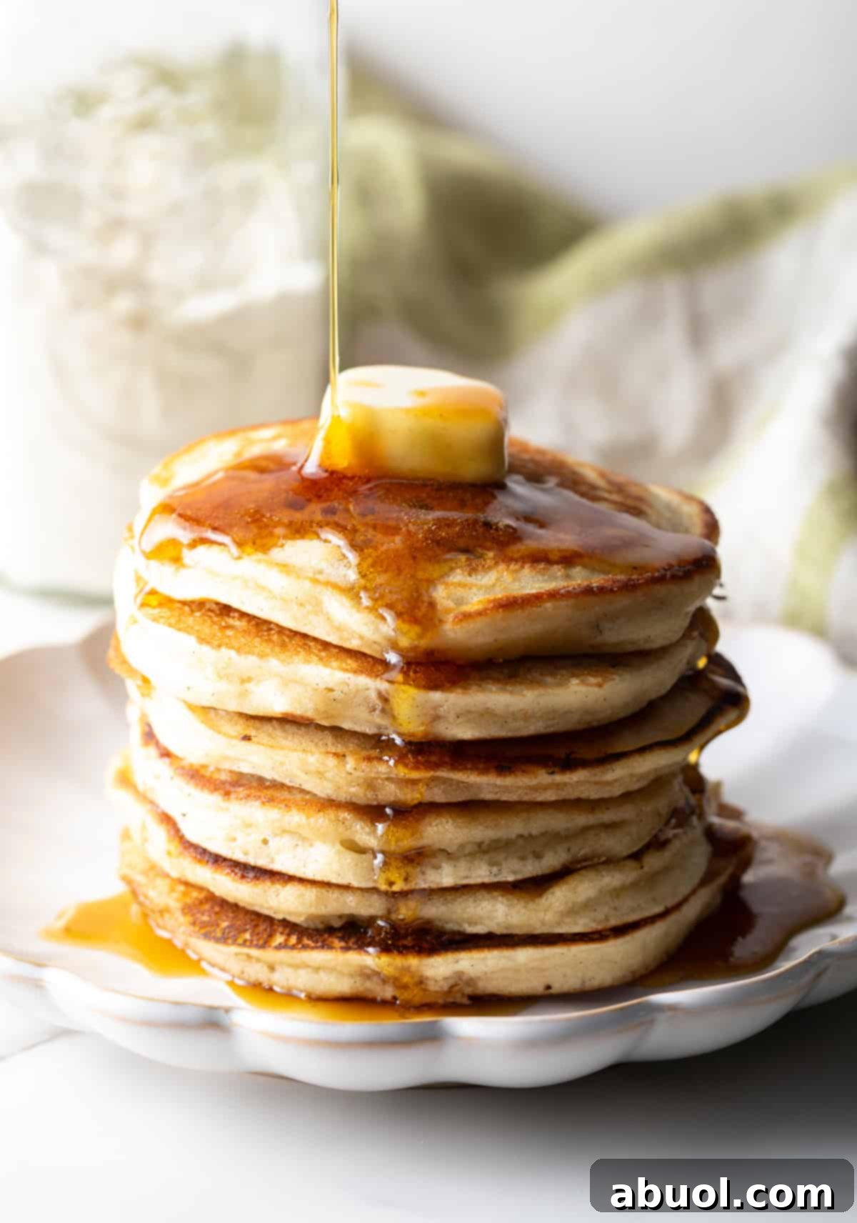 A delicious stack of homemade pancakes with butter and syrup