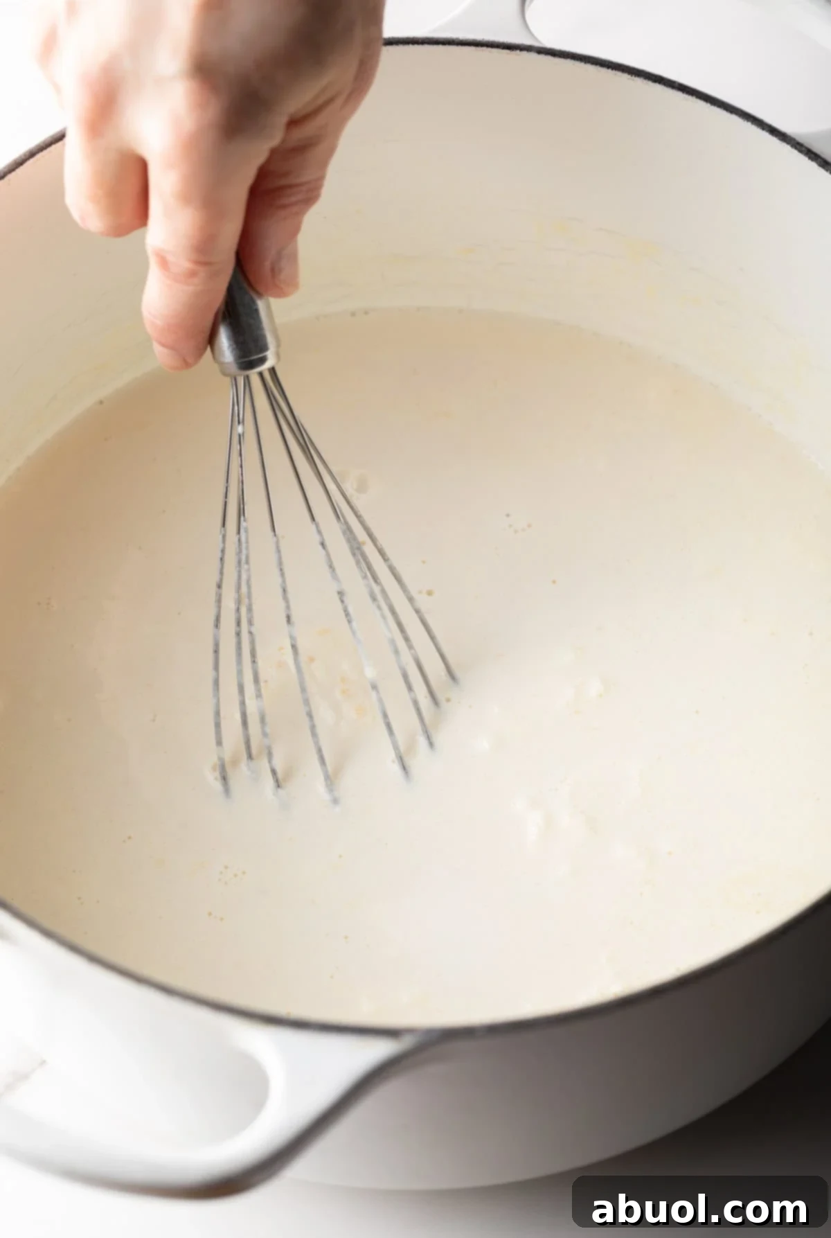 Whisking roux and cream mixture