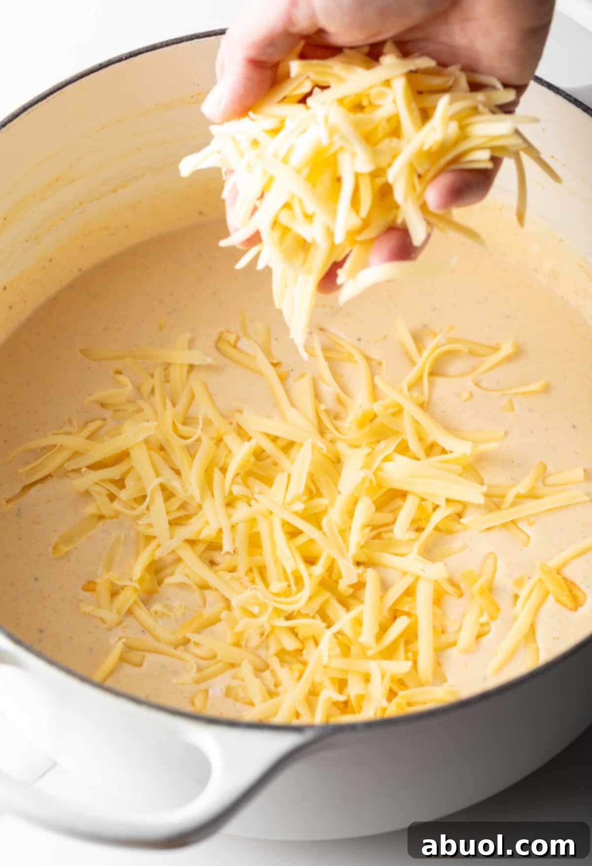 Adding shredded cheese to cream sauce