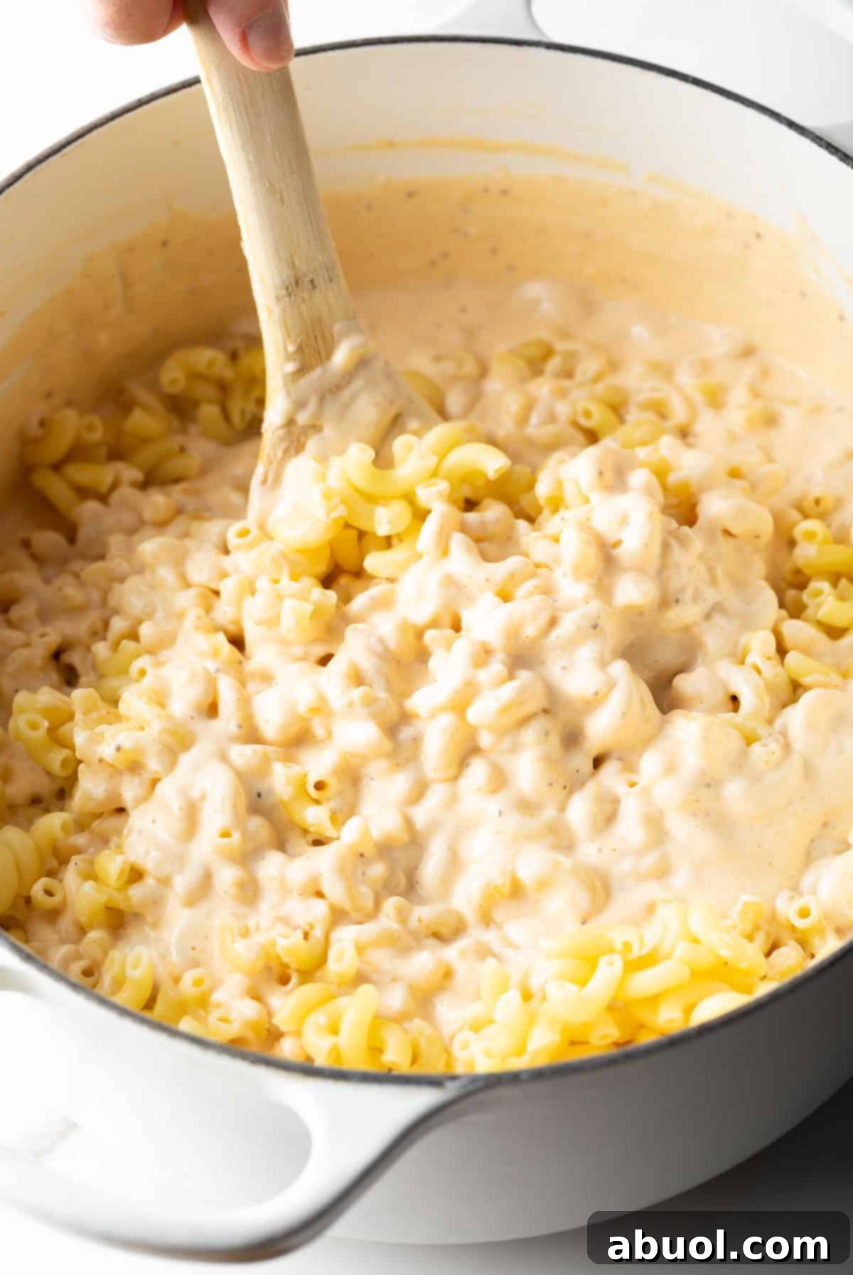 Stirring pasta into cheese sauce