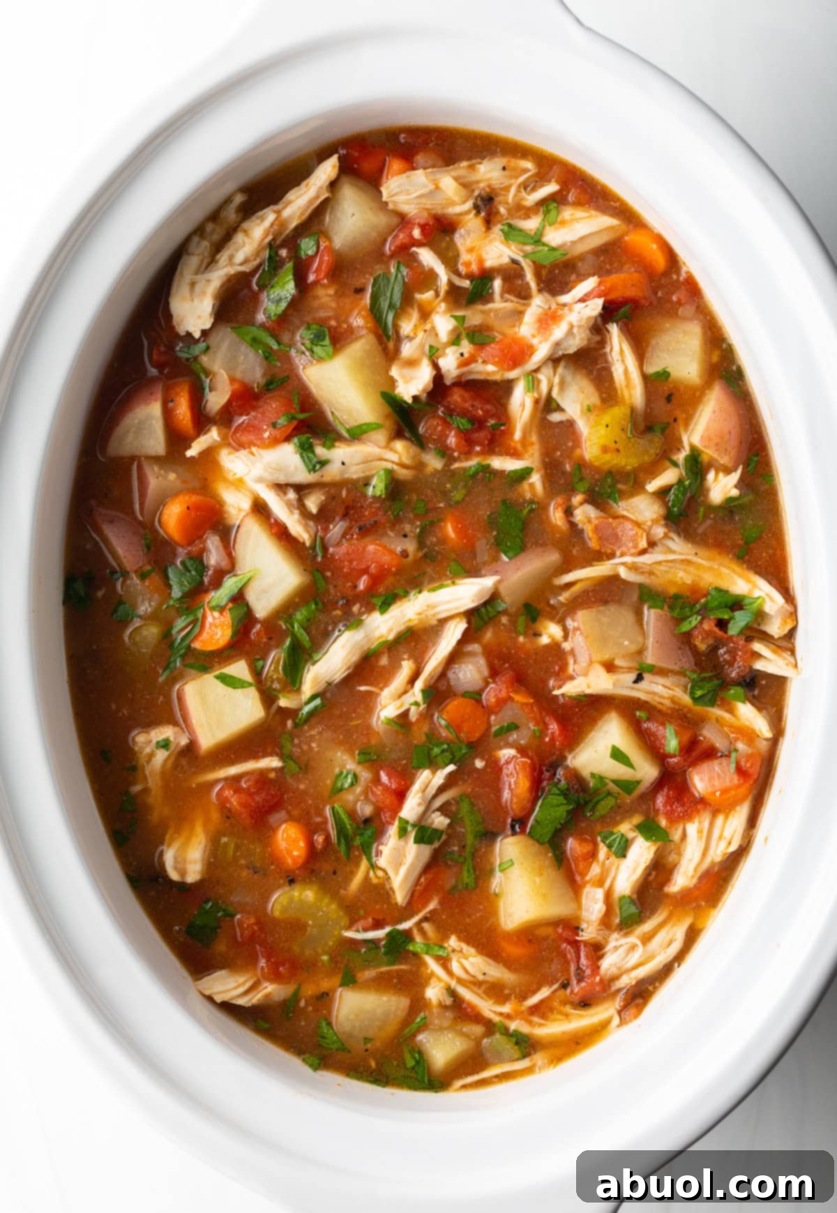 Savory Slow Cooker Chicken Stew 10 Healthy crock pot chicken stew in a white crock pot, ready to serve.