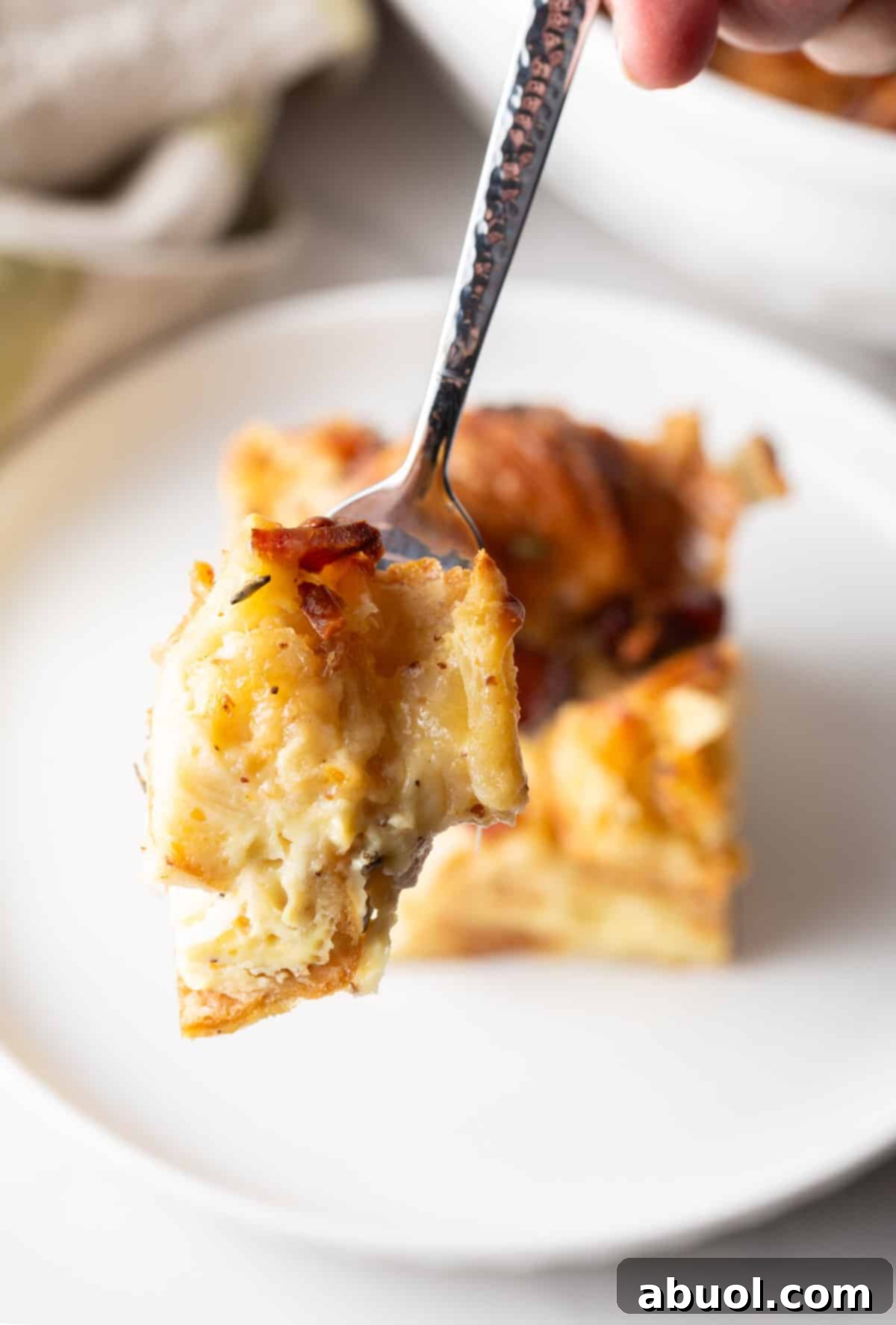 Forkful of casserole held to a camera.