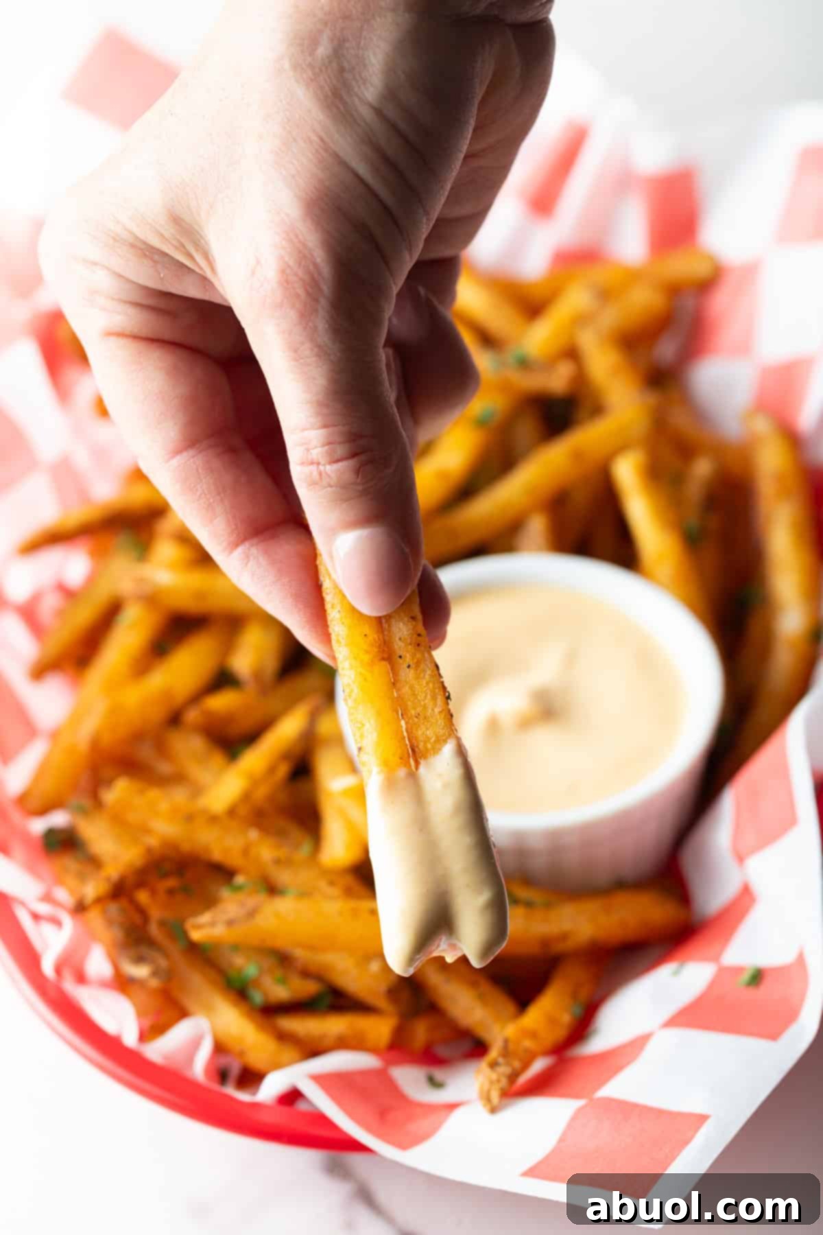 French fries dipped in easy sauce.