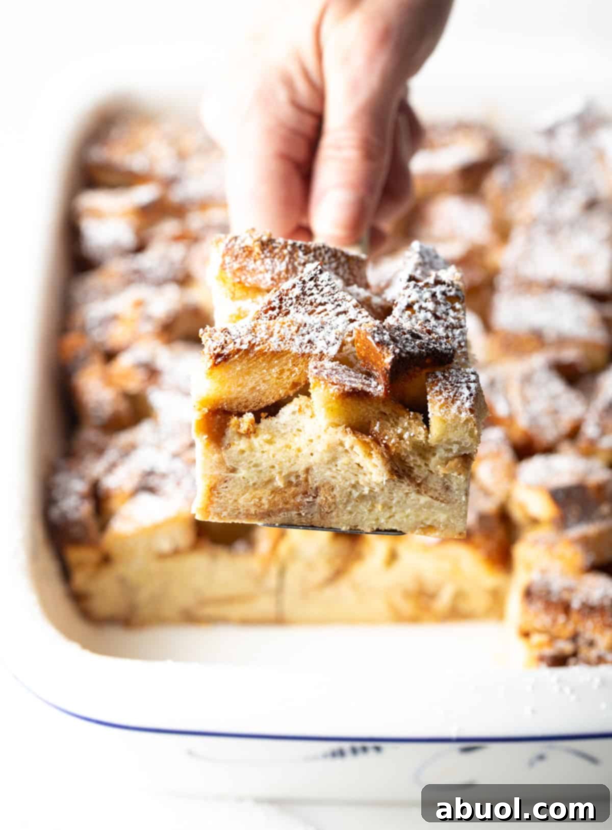 Hand Holding a Square of French Toast Casserole