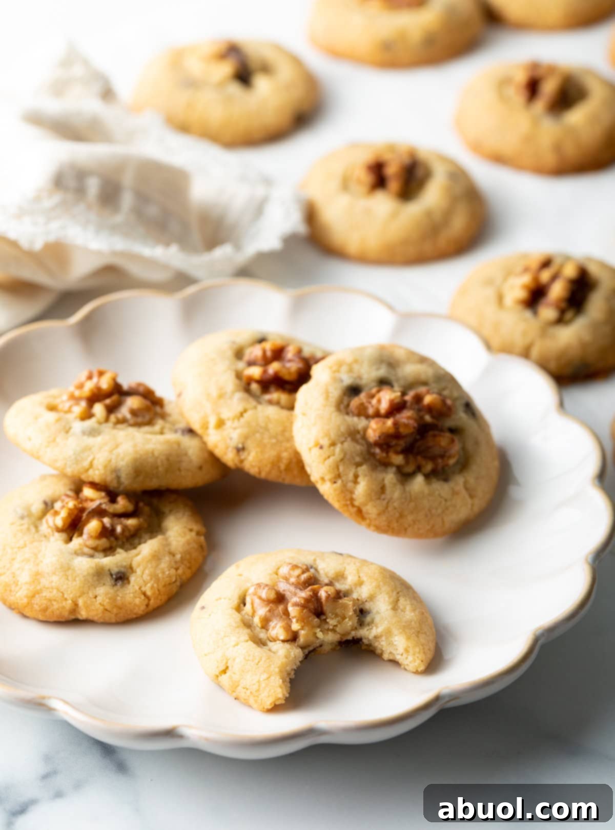 Chocolate chip walnut cookies stacked on a plate.