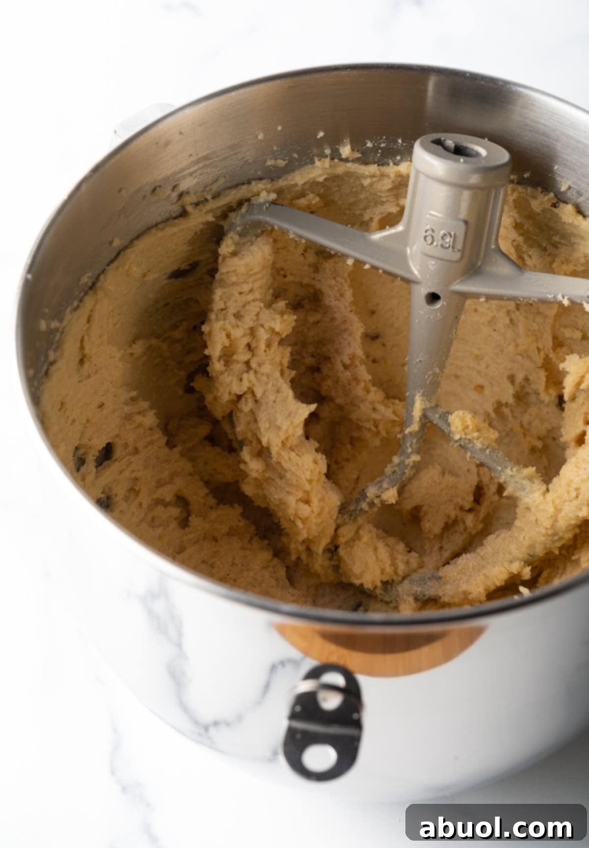 Butter and sugar being mixed in a stand mixer.