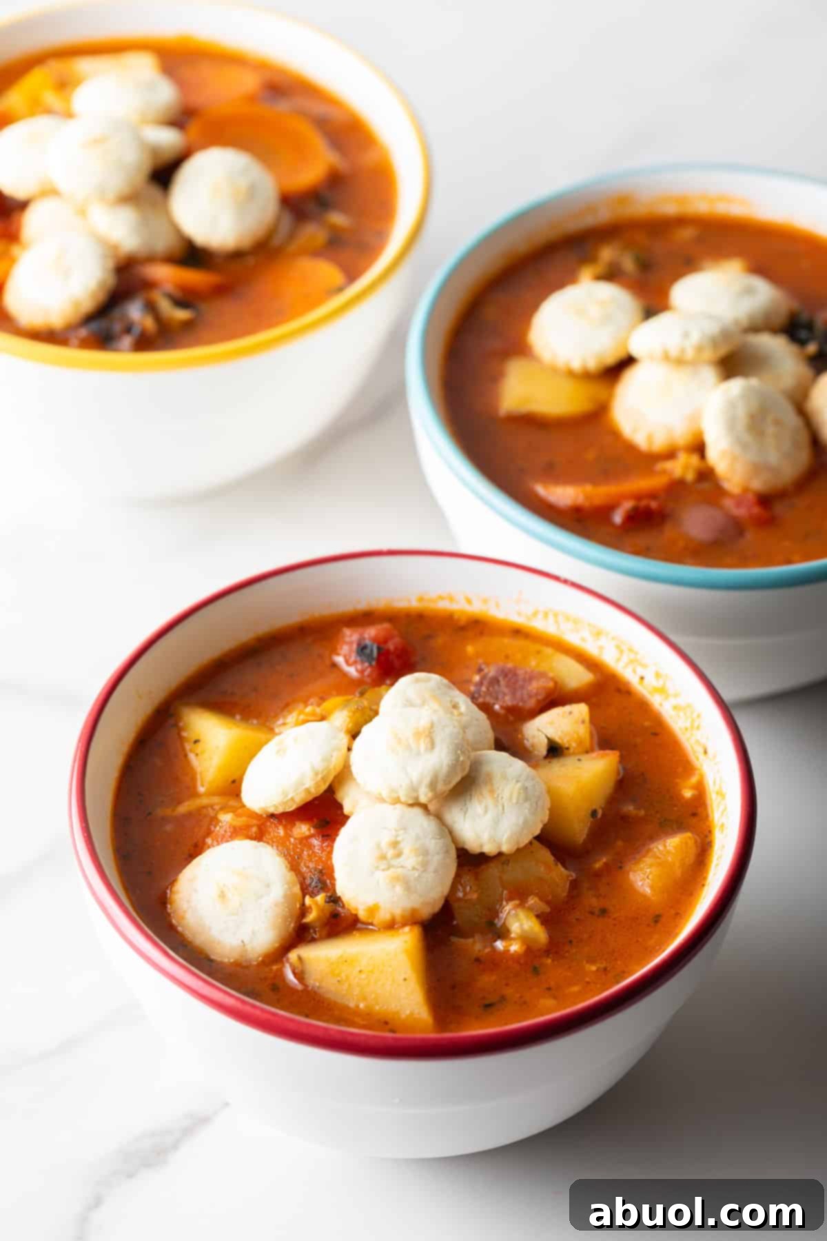 Manhattan clam chowder served in white bowls, topped with oyster crackers.