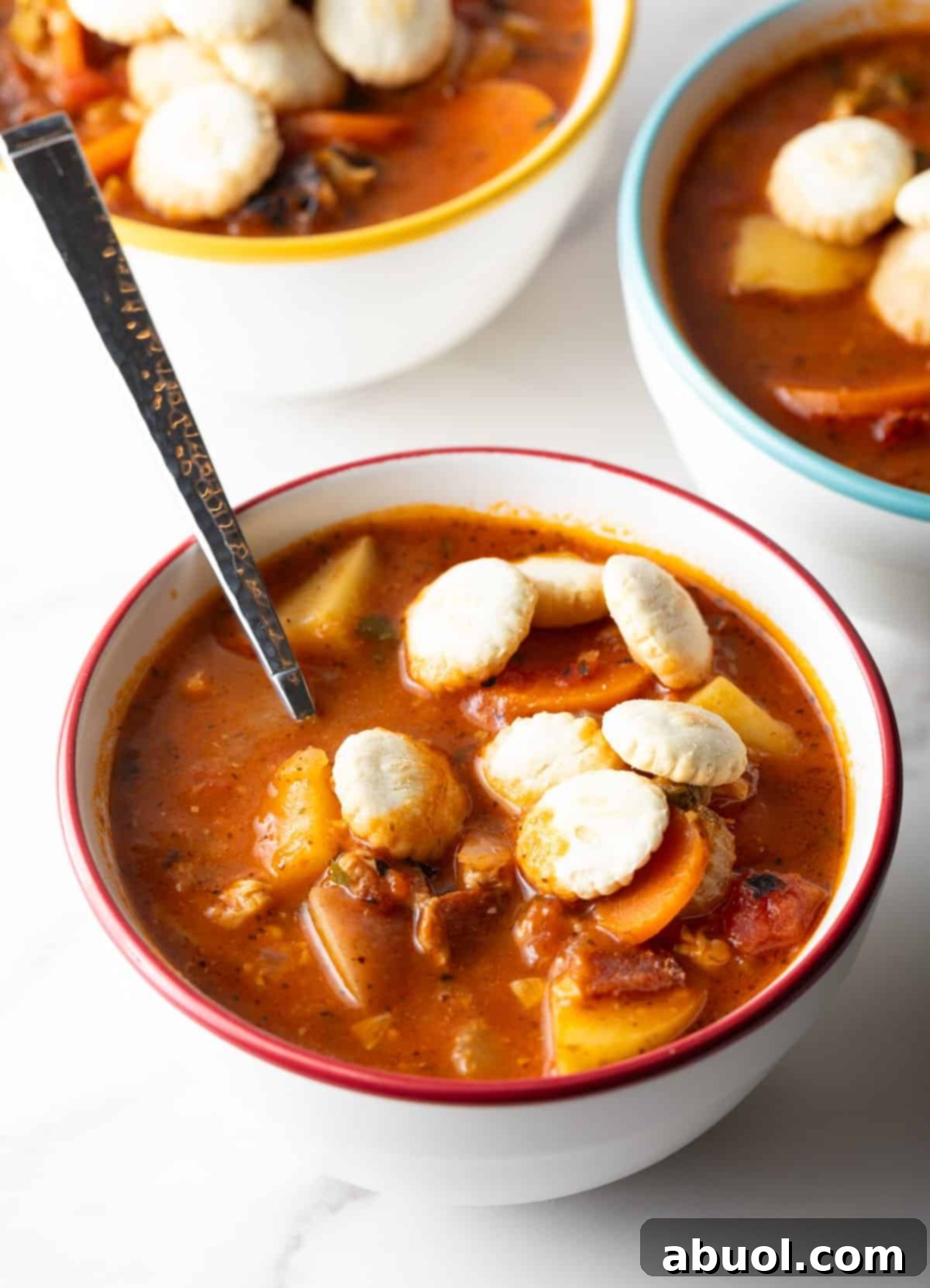 Manhattan clam chowder with oyster crackers and a spoon.
