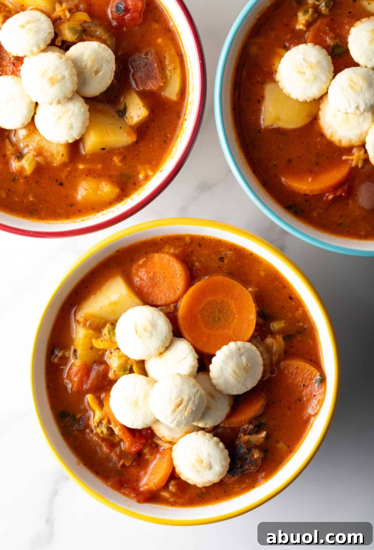 Overhead view of bowls of Manhattan clam chowder topped with oyster crackers.