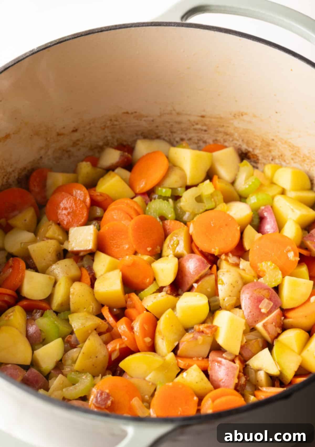 Bacon and vegetables cooking in a pot.