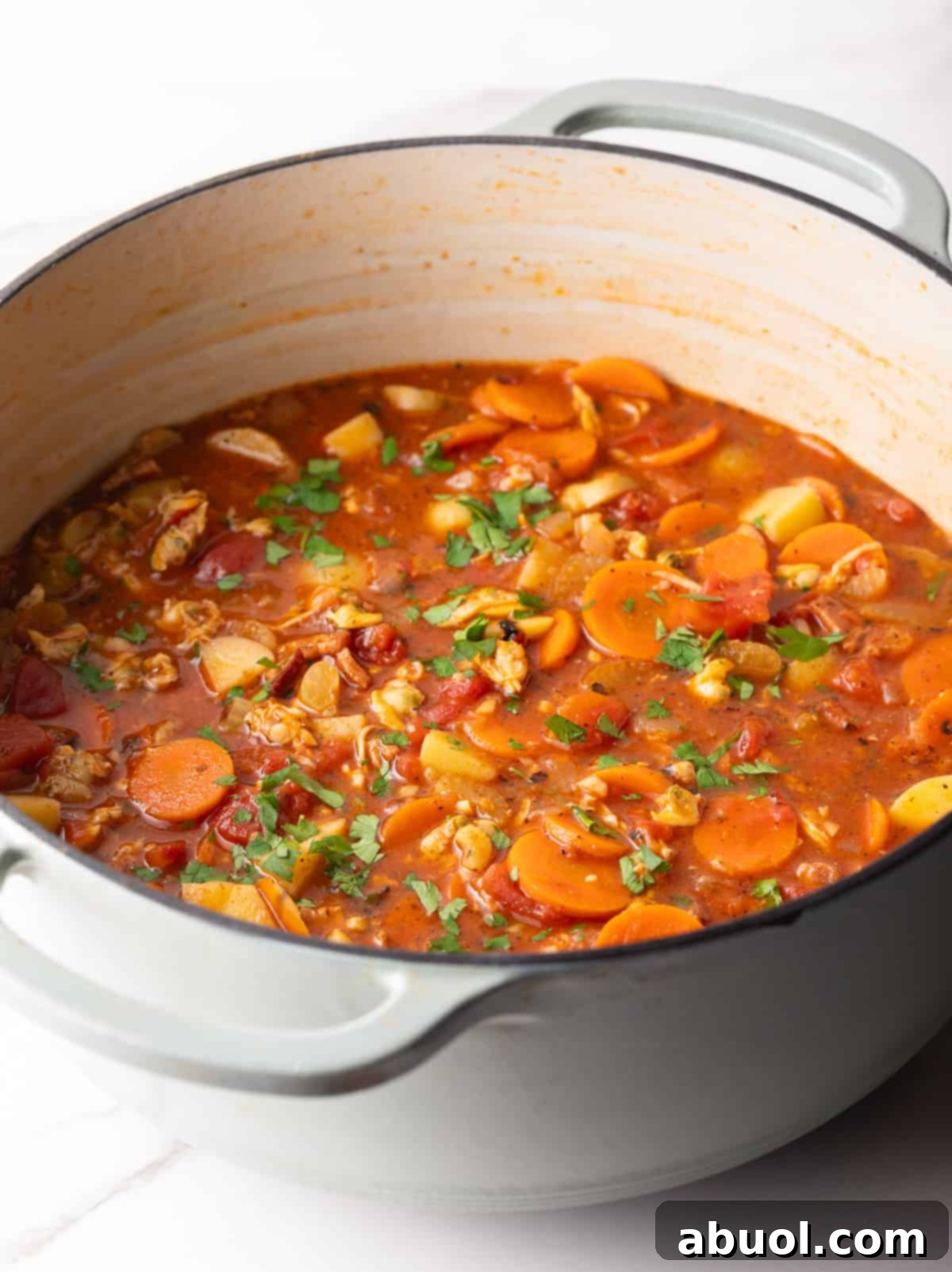 Pot of ready-to-serve Manhattan clam chowder topped with fresh parsley.