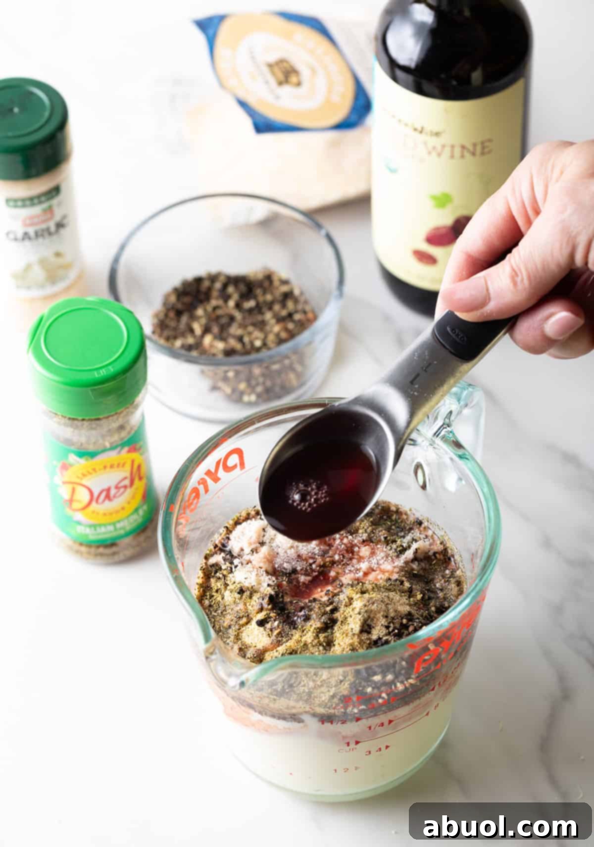 Red wine vinegar being added to the Peppercorn Parmesan Salad Dressing