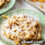 Overhead shot of homemade funnel cake with powdered sugar on a green plate.
