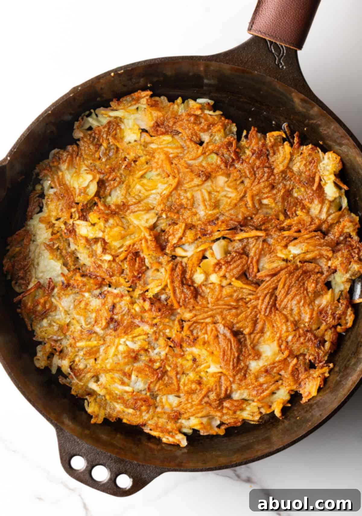 Crispy homemade hashbrowns in a black skillet.