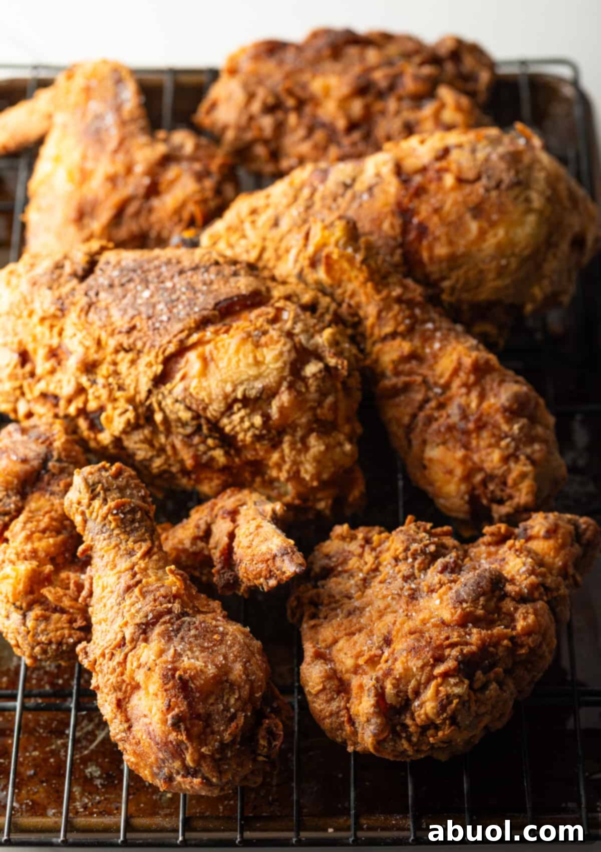 Southern Cast Iron Fried Chicken 12 Crispy southern fried chicken cooked in a cast iron skillet draining on a roasting tray, looking delicious.