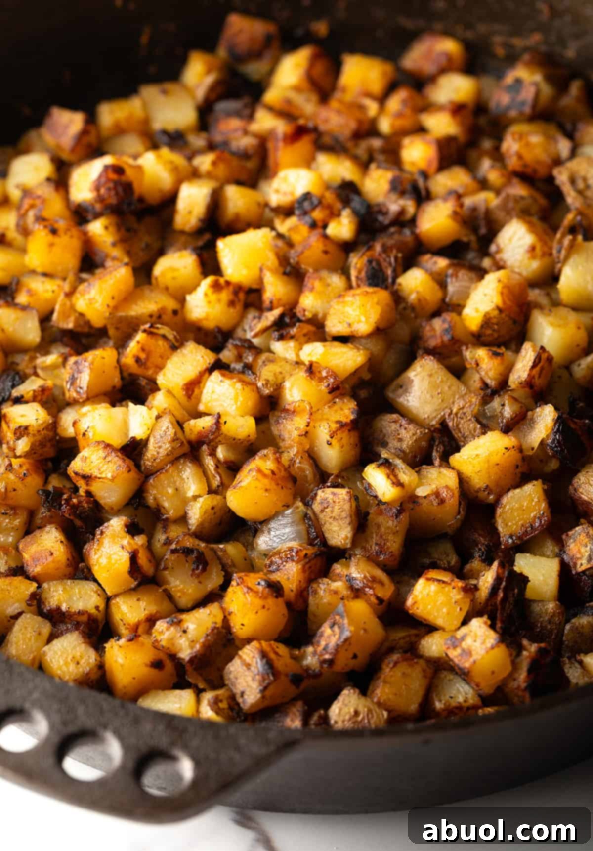 Golden Pan Fried Potatoes 3 A cast-iron skillet full of perfectly browned, crispy pan-fried potatoes.