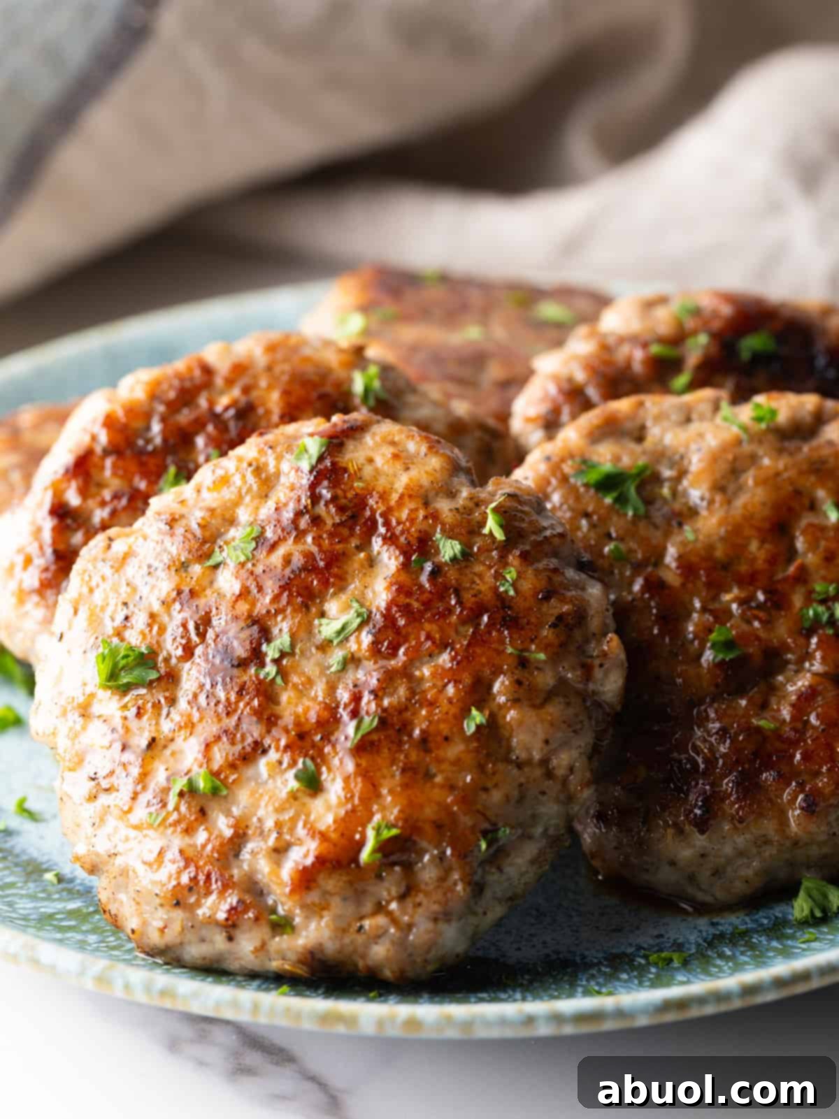 A close-up shot of homemade breakfast sausage patties arranged neatly on a serving plate.