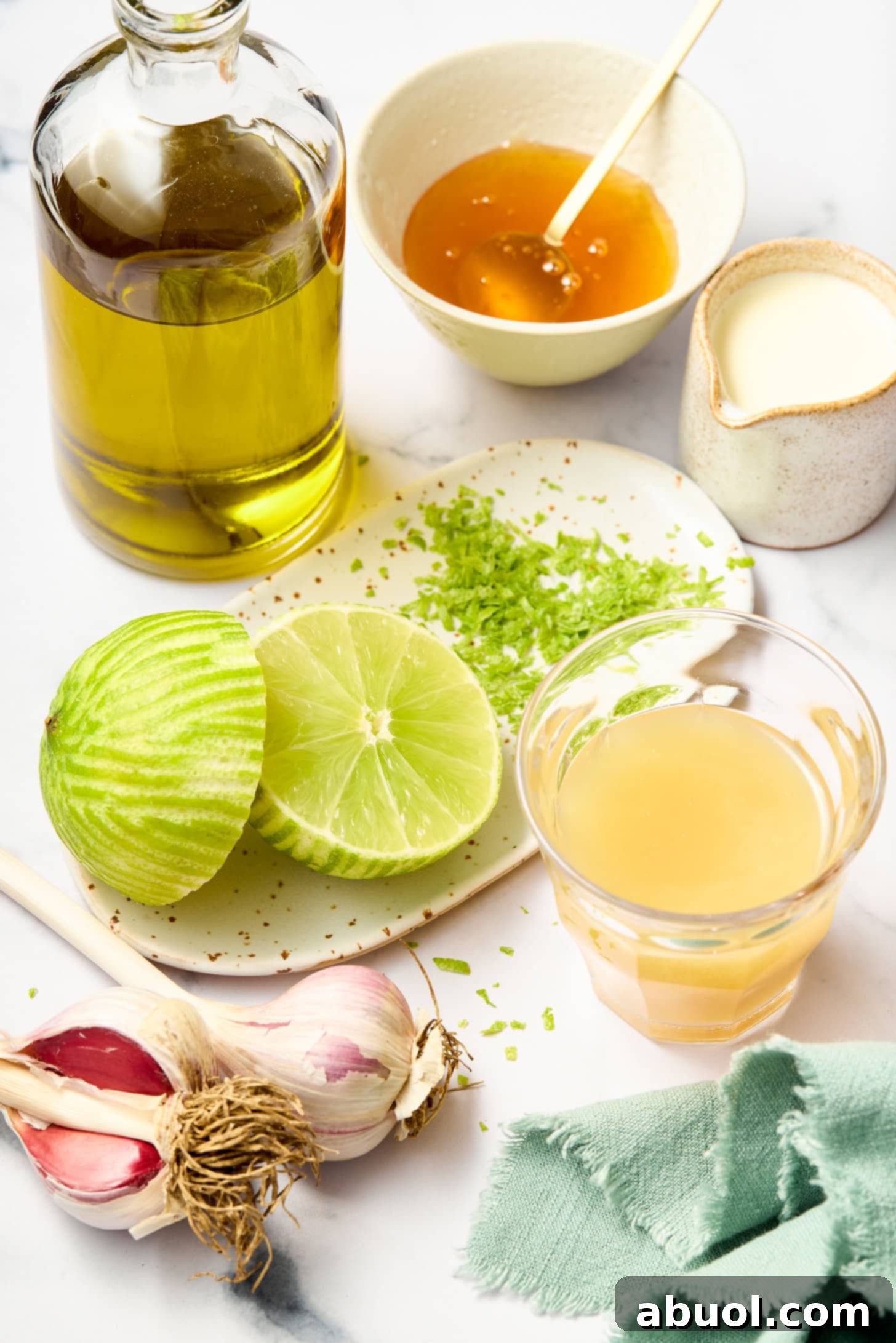 Ingredients for lime vinaigrette laid out: olive oil, fresh limes, lime juice, honey, and seasonings.