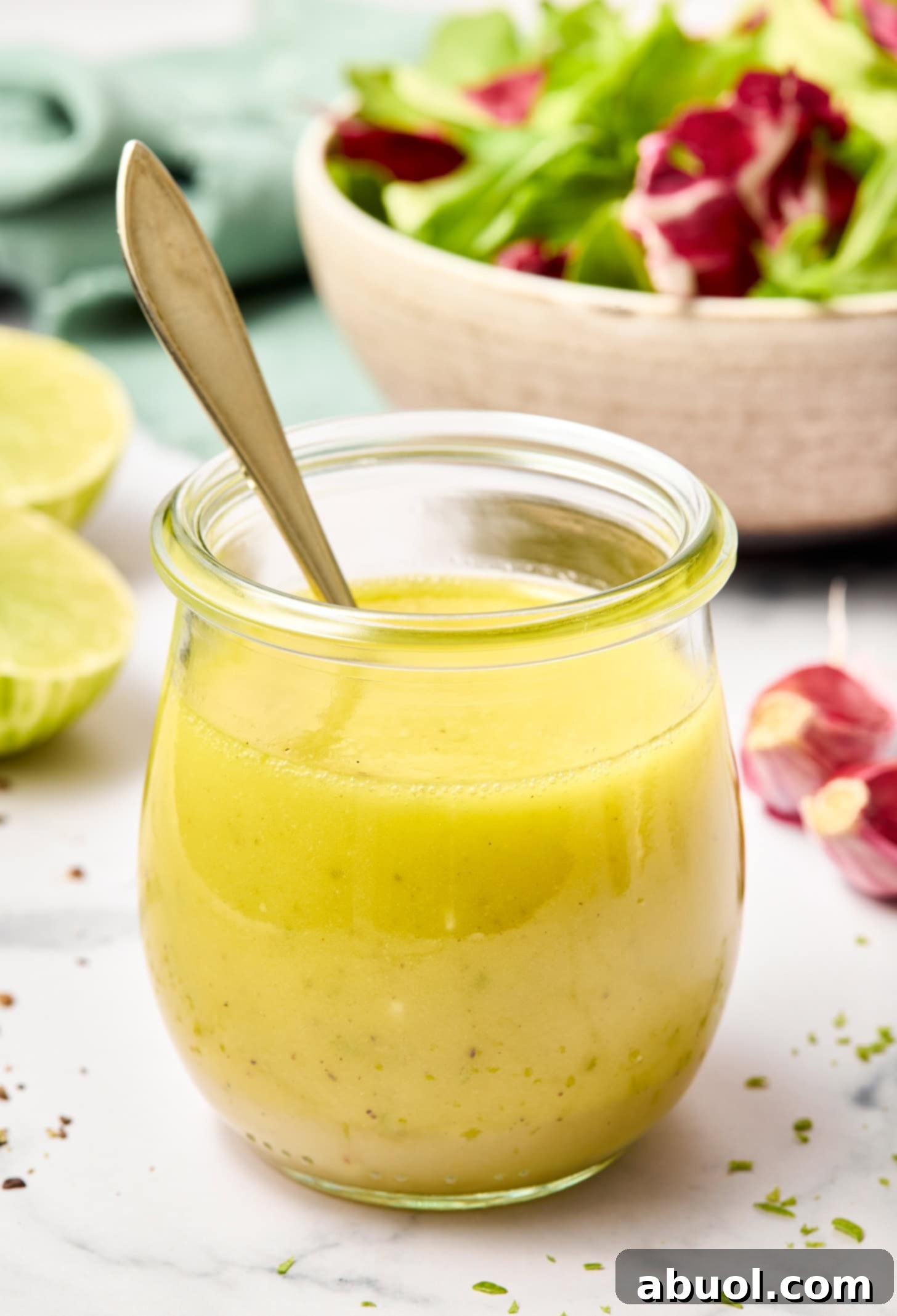 The finished honey lime dressing, creamy and emulsified in a glass jar, ready to be served.
