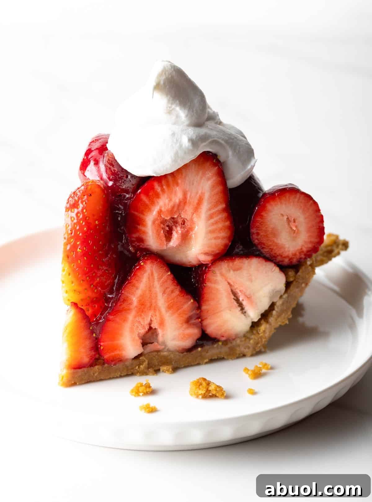 A slice of easy strawberry pie with whipped cream on top.