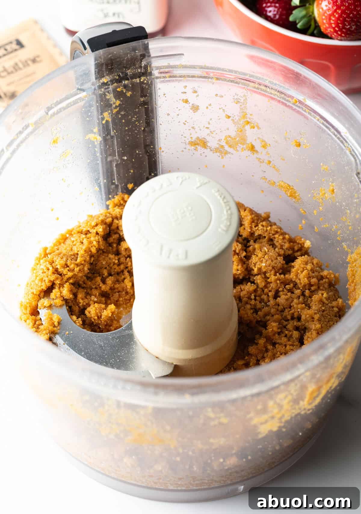 Ginger snap cookies are being pulsed in a food processor to make a crust for a strawberry pie recipe.