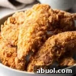 Crispy deep fried chicken tenders sitting in a white bowl.
