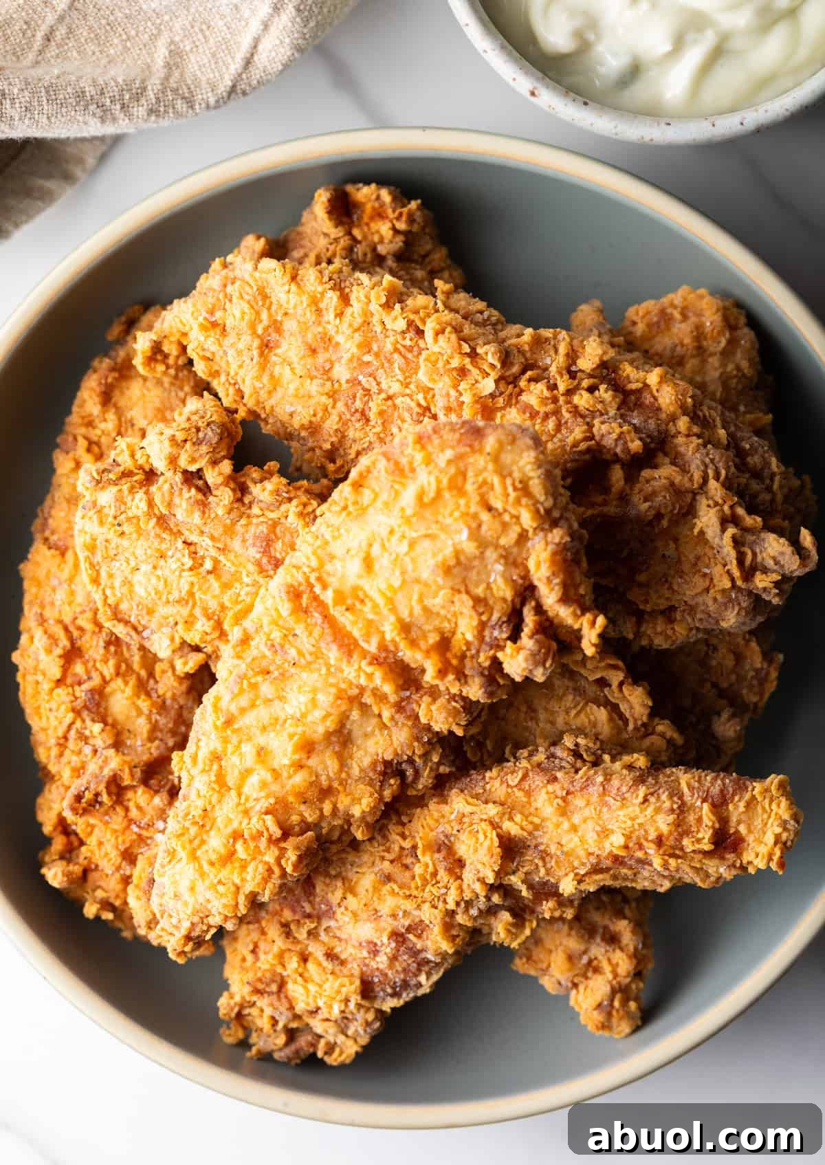 An overhead shot of a bowl filled with a deep fried chicken tenders recipe.