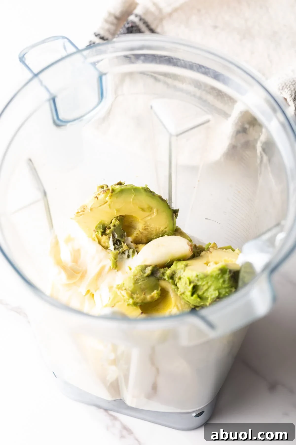 Creamy Avocado Lime Ranch Dressing Recipe 6 Mayonnaise, avocado slices, and lime juice sitting in a blender.