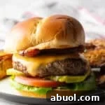 A juicy deer burger recipe featuring a deer burger patty between two buns and topped with cheese and condiments.