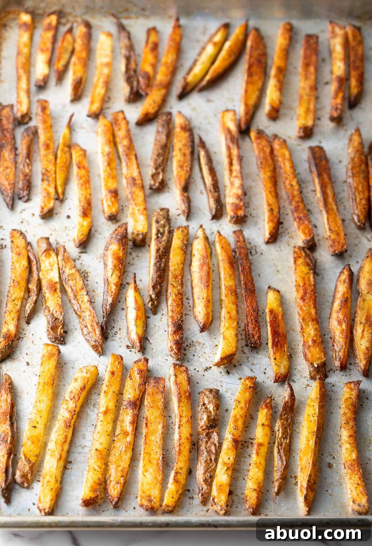 Crispy oven baked French fries on a baking sheet.