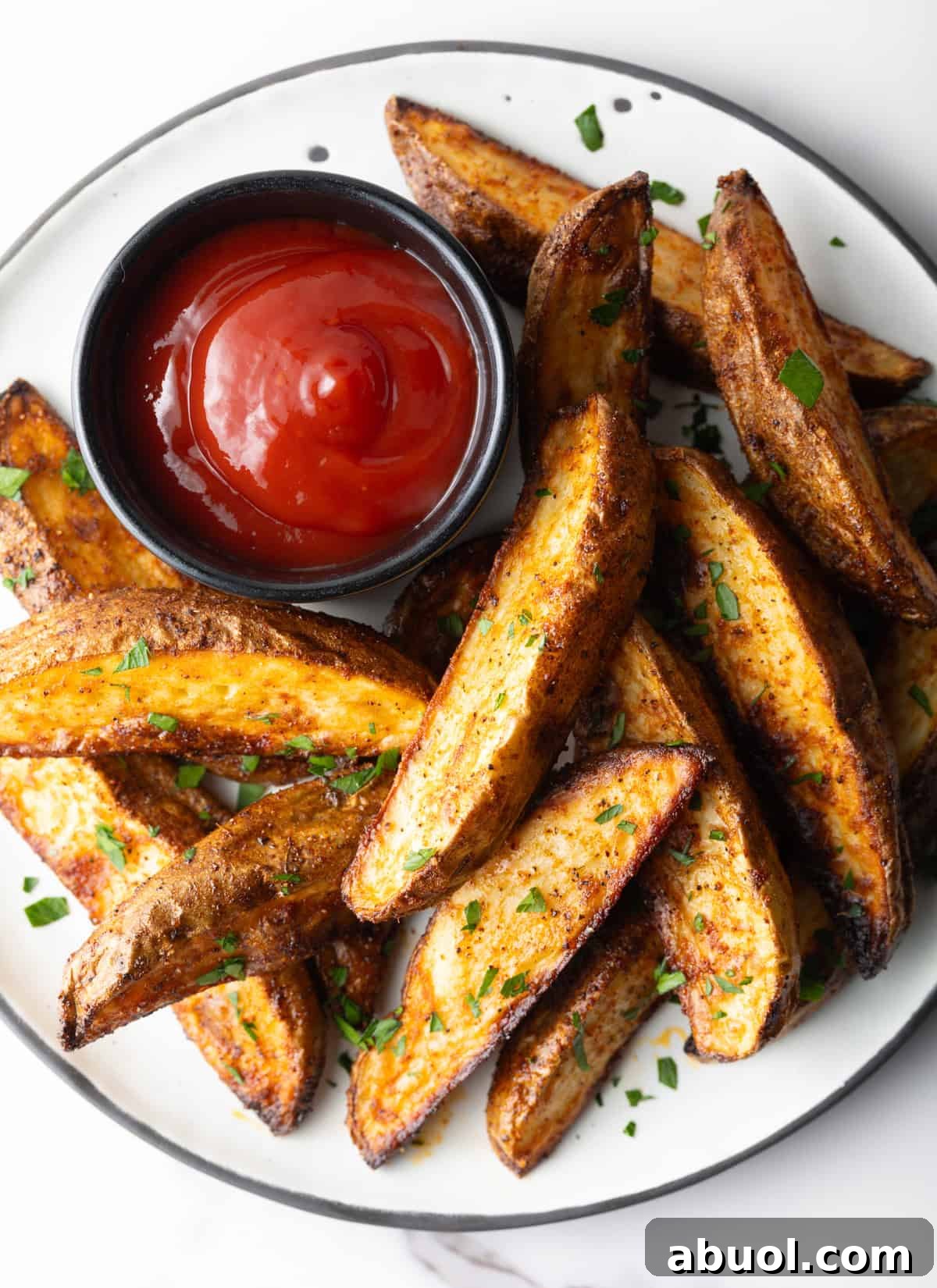 A plate of easy baked potato wedges with a side of ketchup.