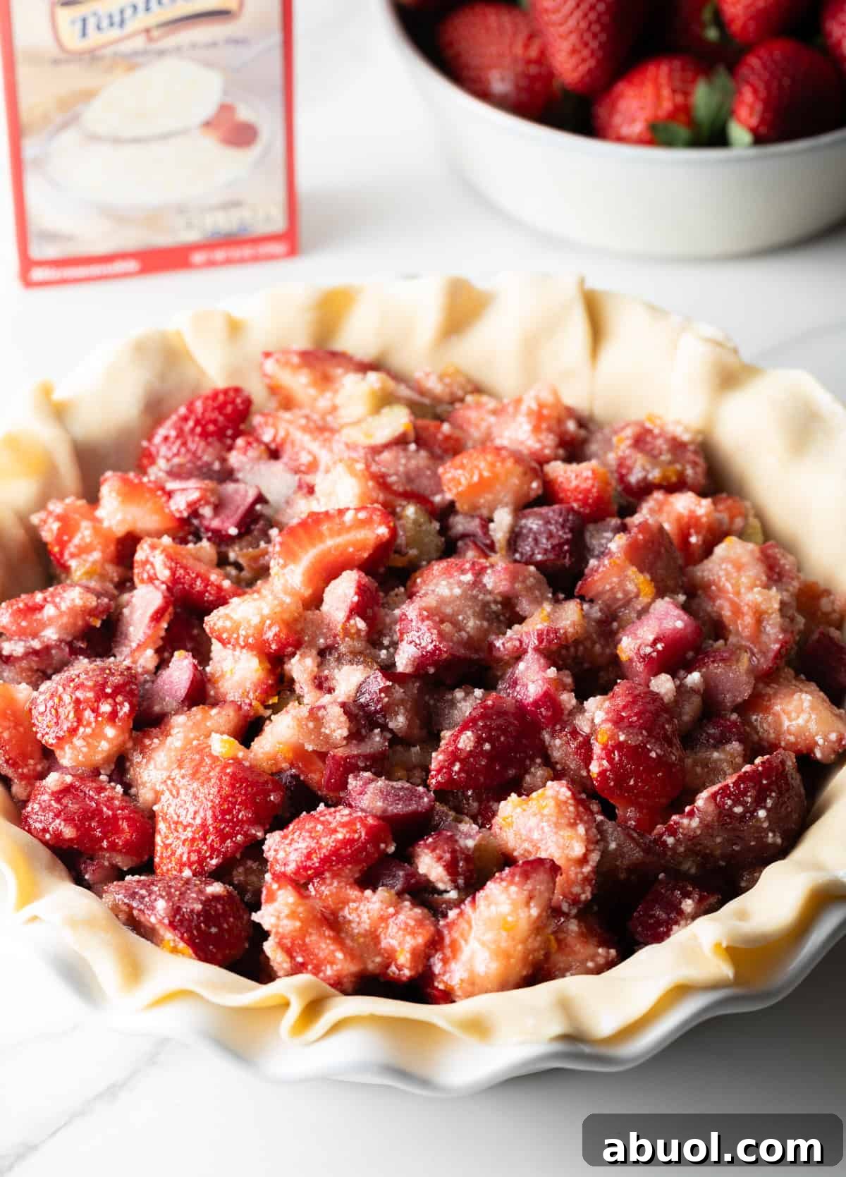 A strawberry rhubarb pie mixture is topping a pie crust.