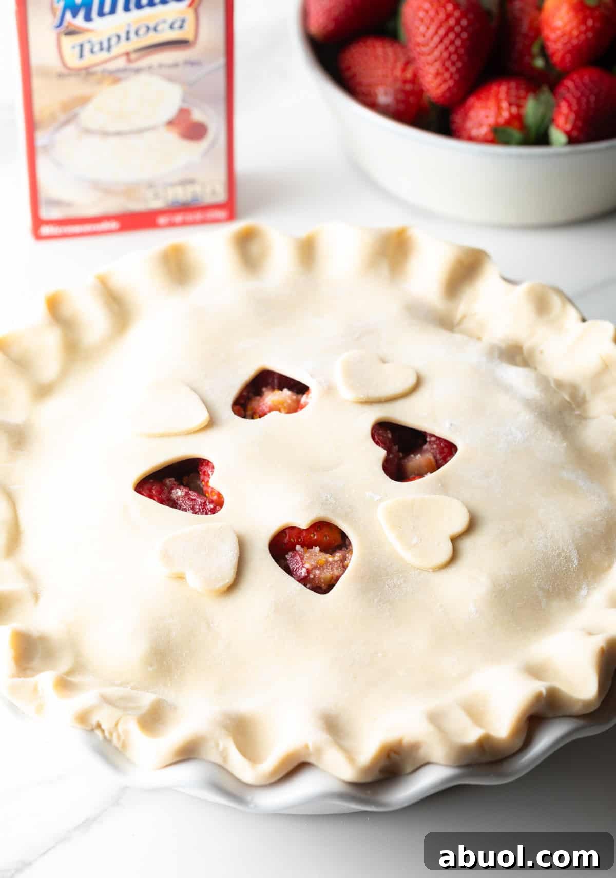 A fully assembled strawberry pie with rhubarb, ready for baking.