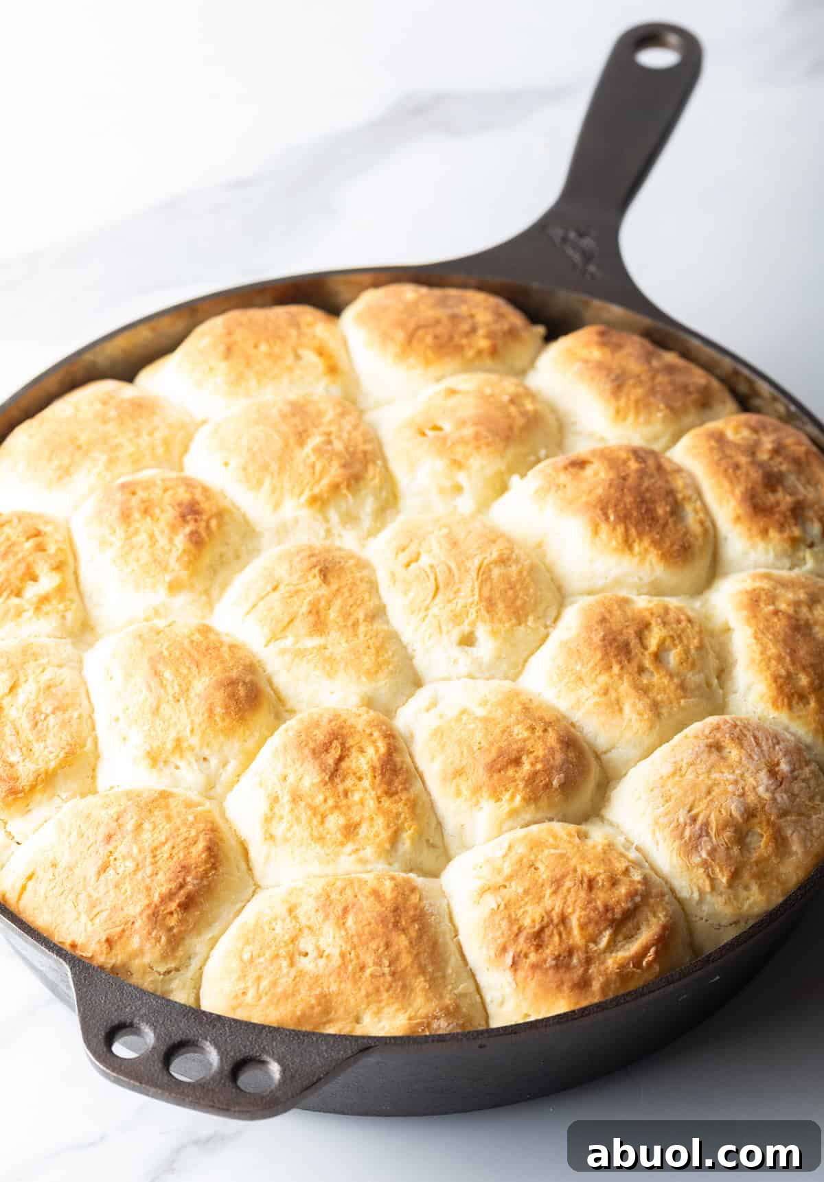 Freshly baked yeast biscuits in a black skillet.